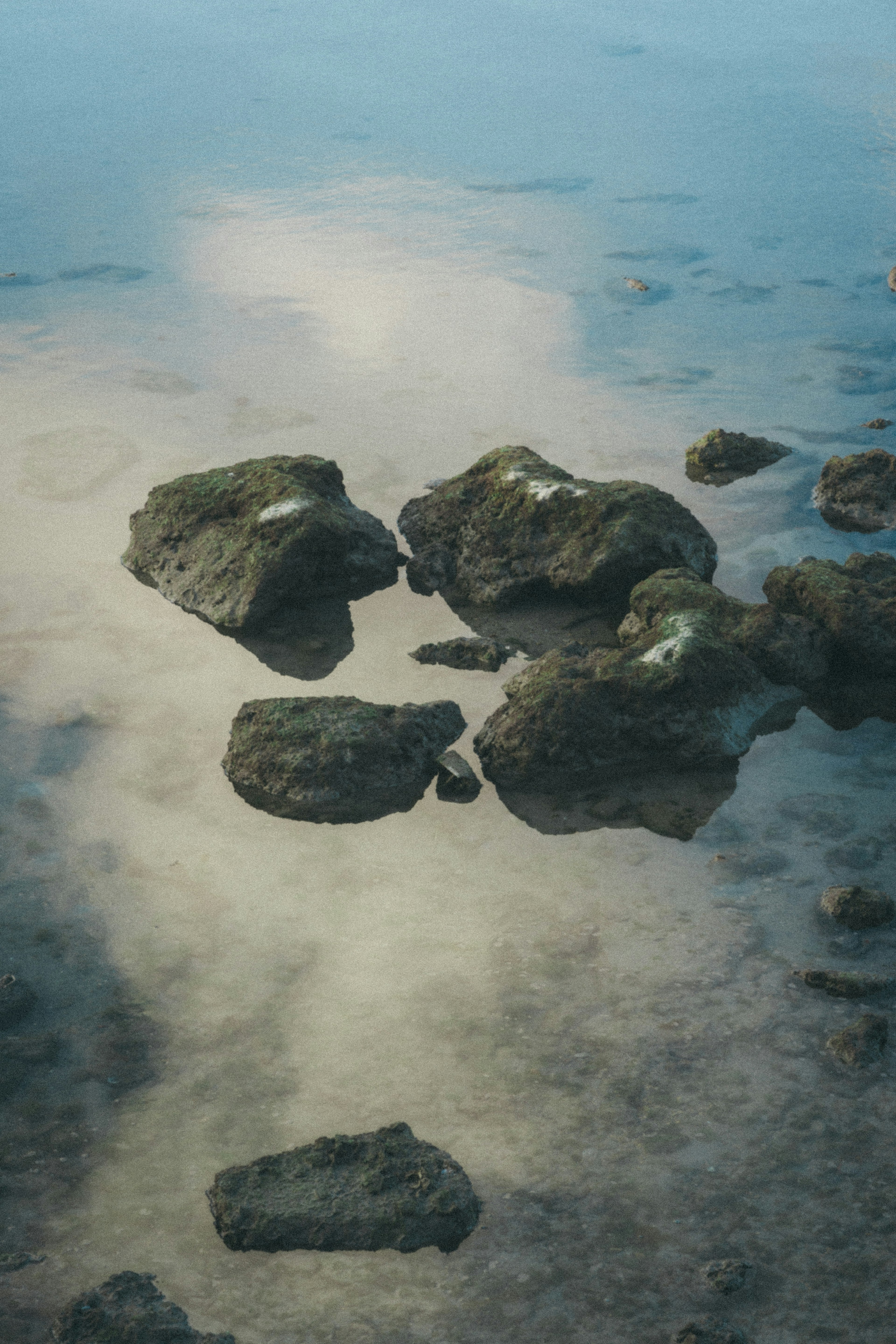 Rocks floating on the water surface with reflections