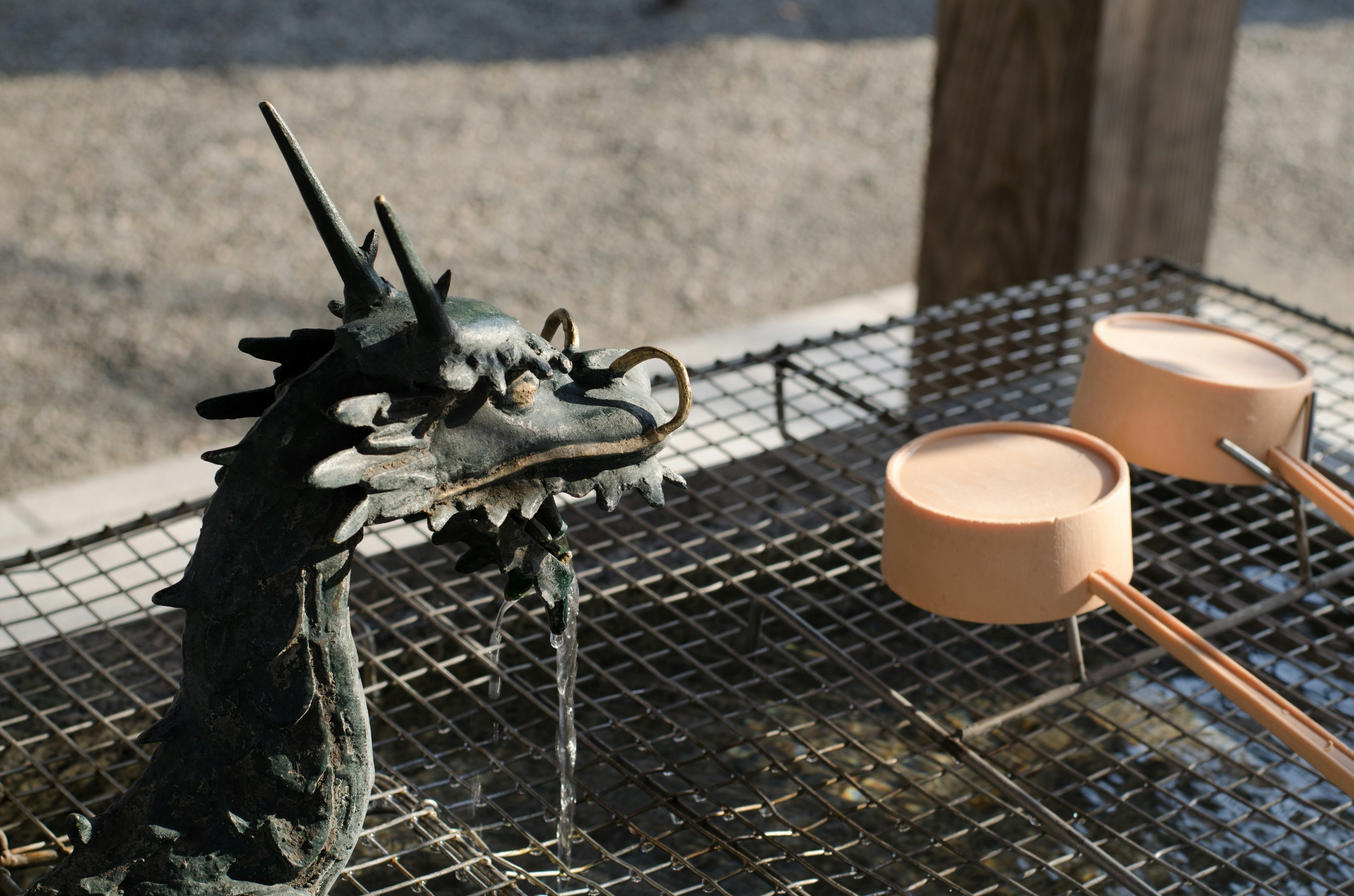 Une sculpture de dragon versant de l'eau et des louches en bois