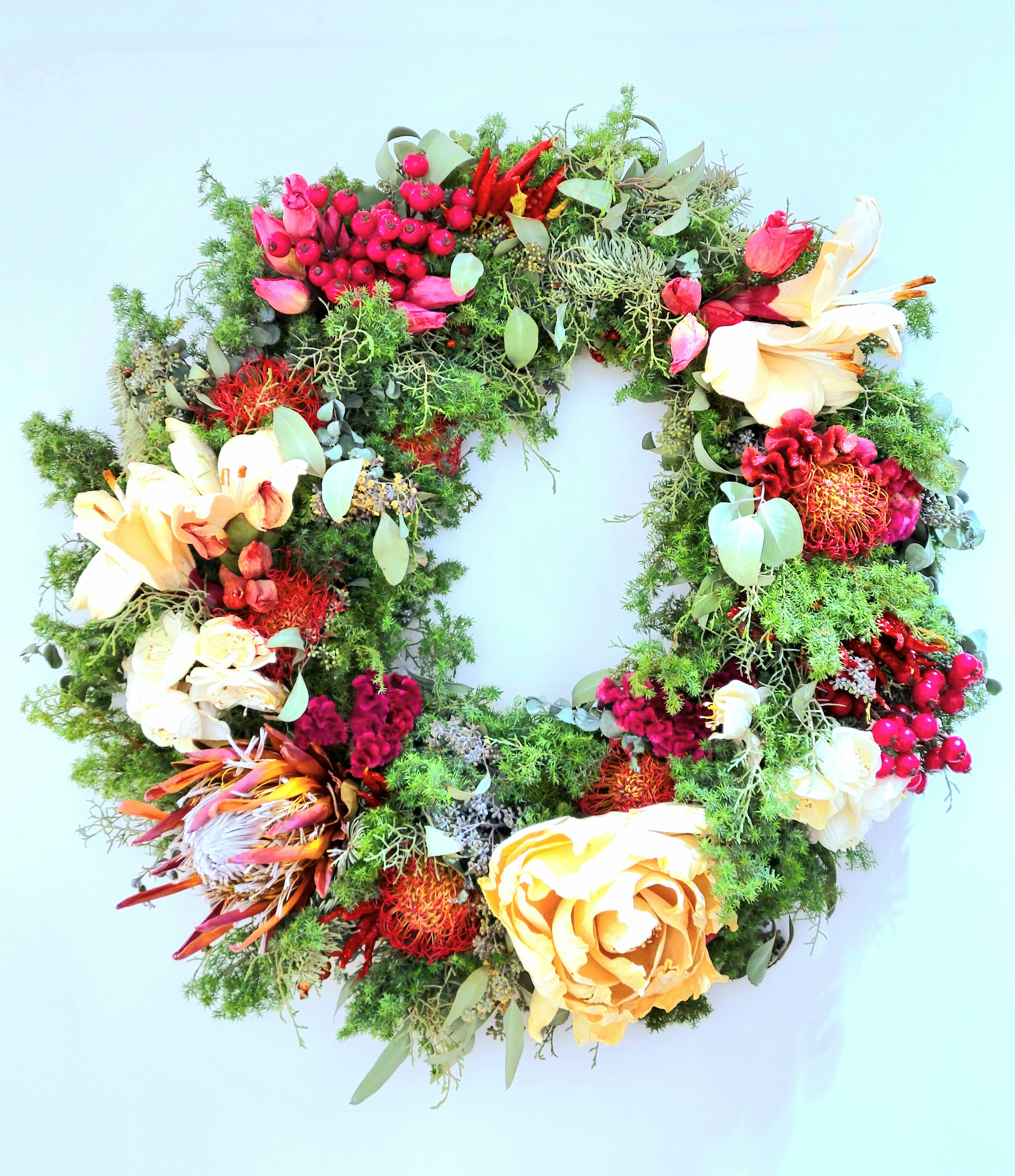 Colorful wreath decorated with flowers and green leaves