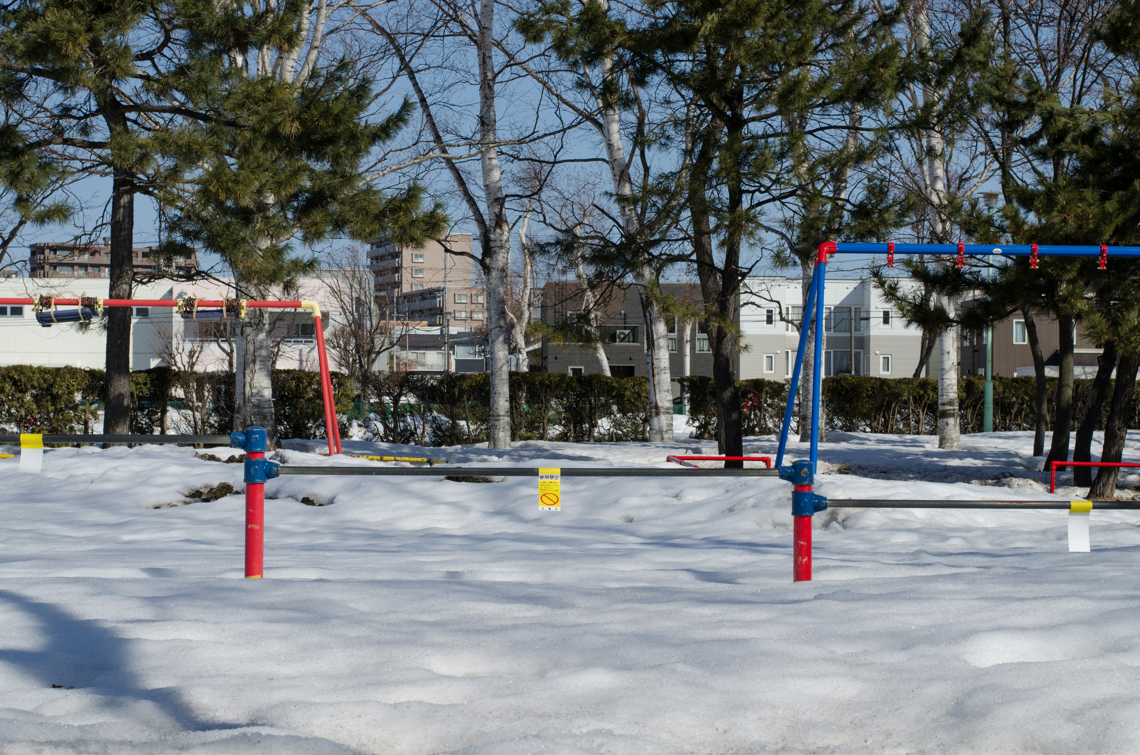 Swings in a winter park covered with snow