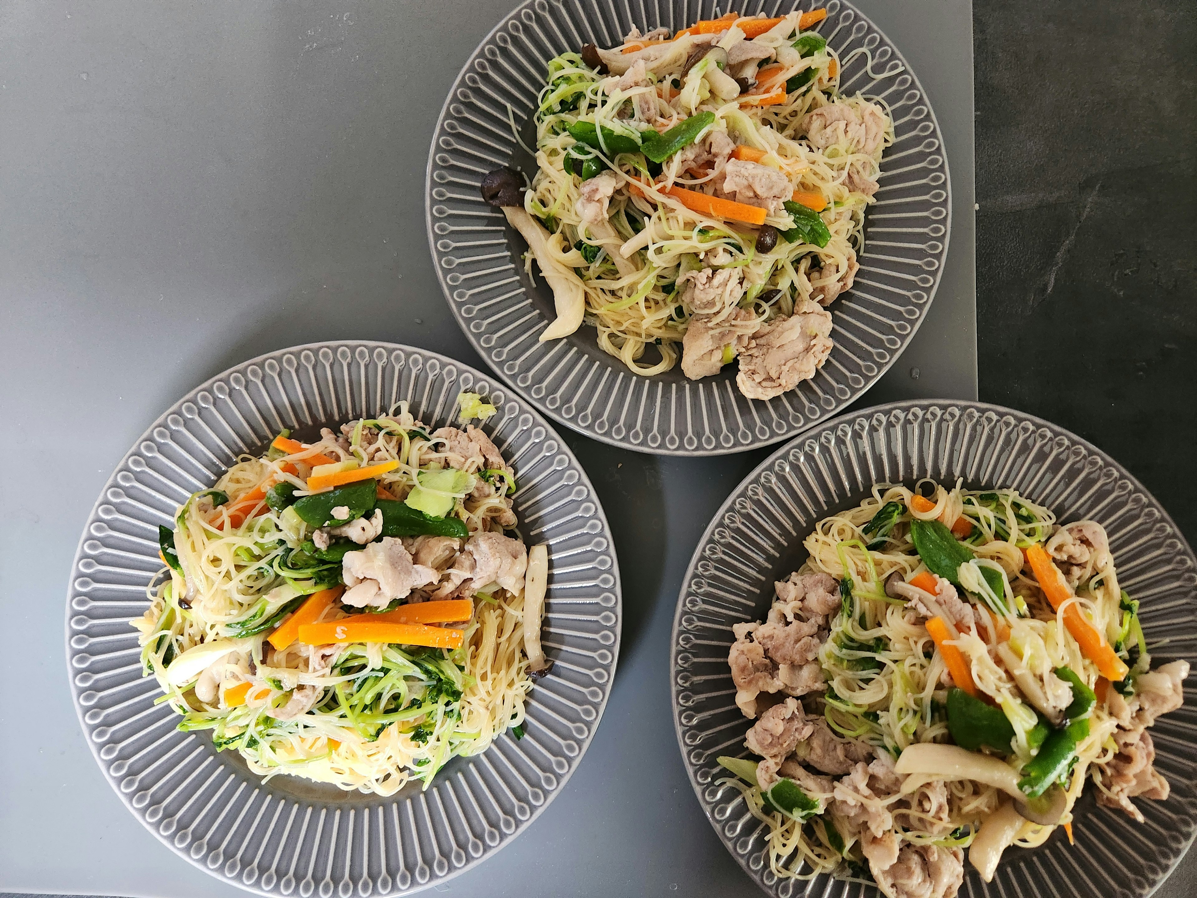 三つの皿に盛られた野菜と肉の入った焼きそば