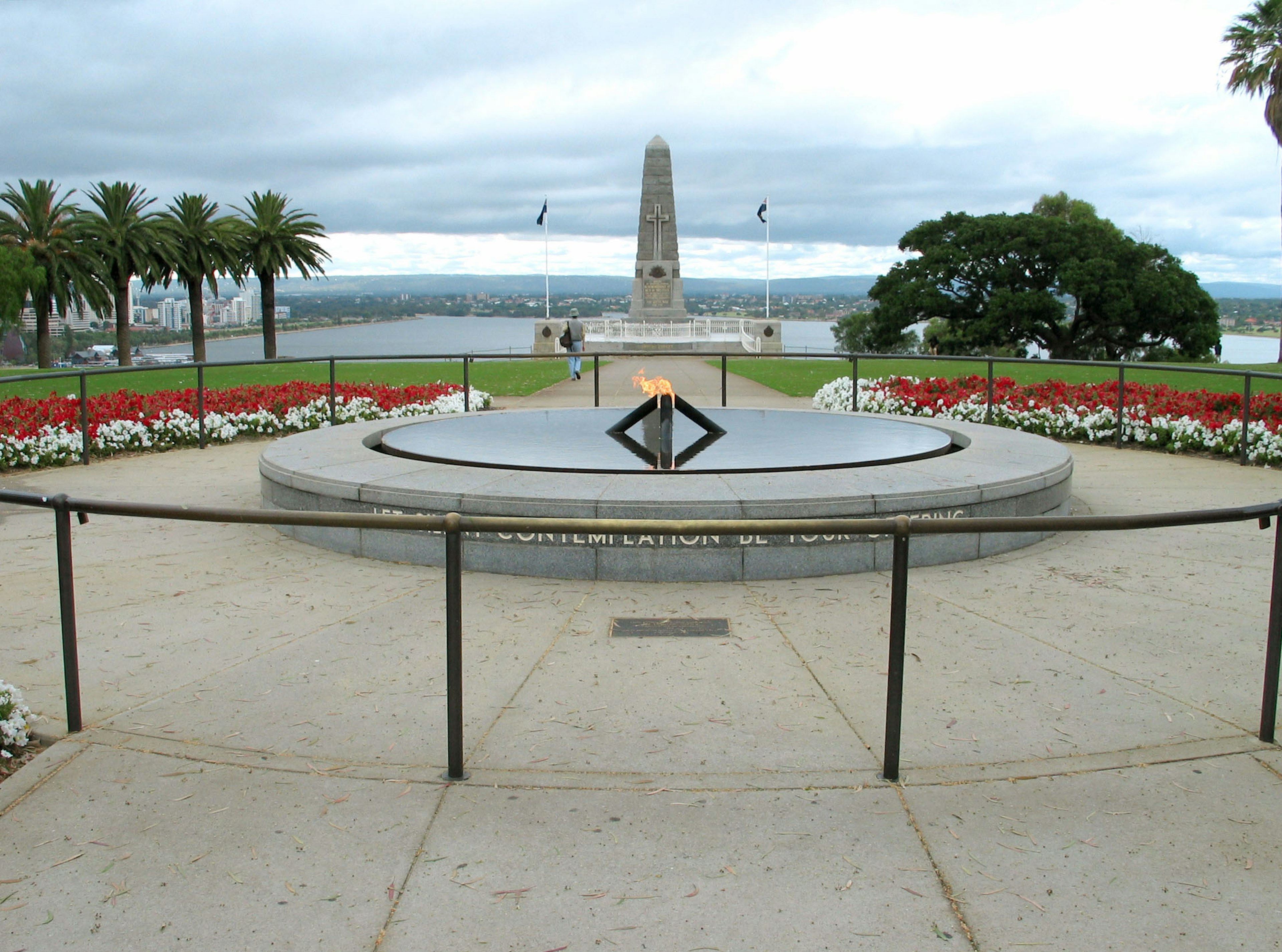 Vista de un memorial en el parque con un monumento de llama