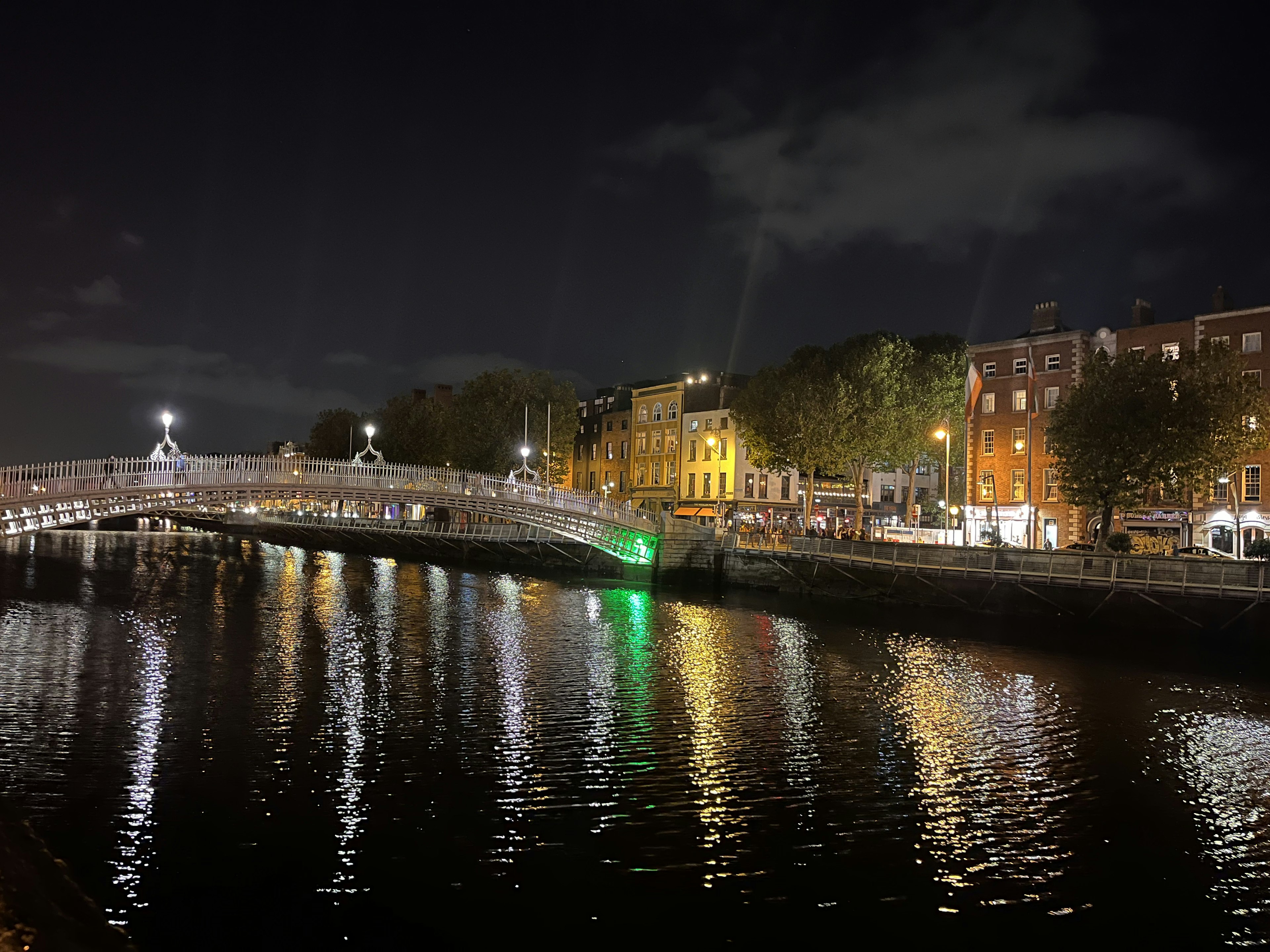 Pemandangan malam Dublin dengan Jembatan Ha'penny dan pantulan di Sungai Liffey