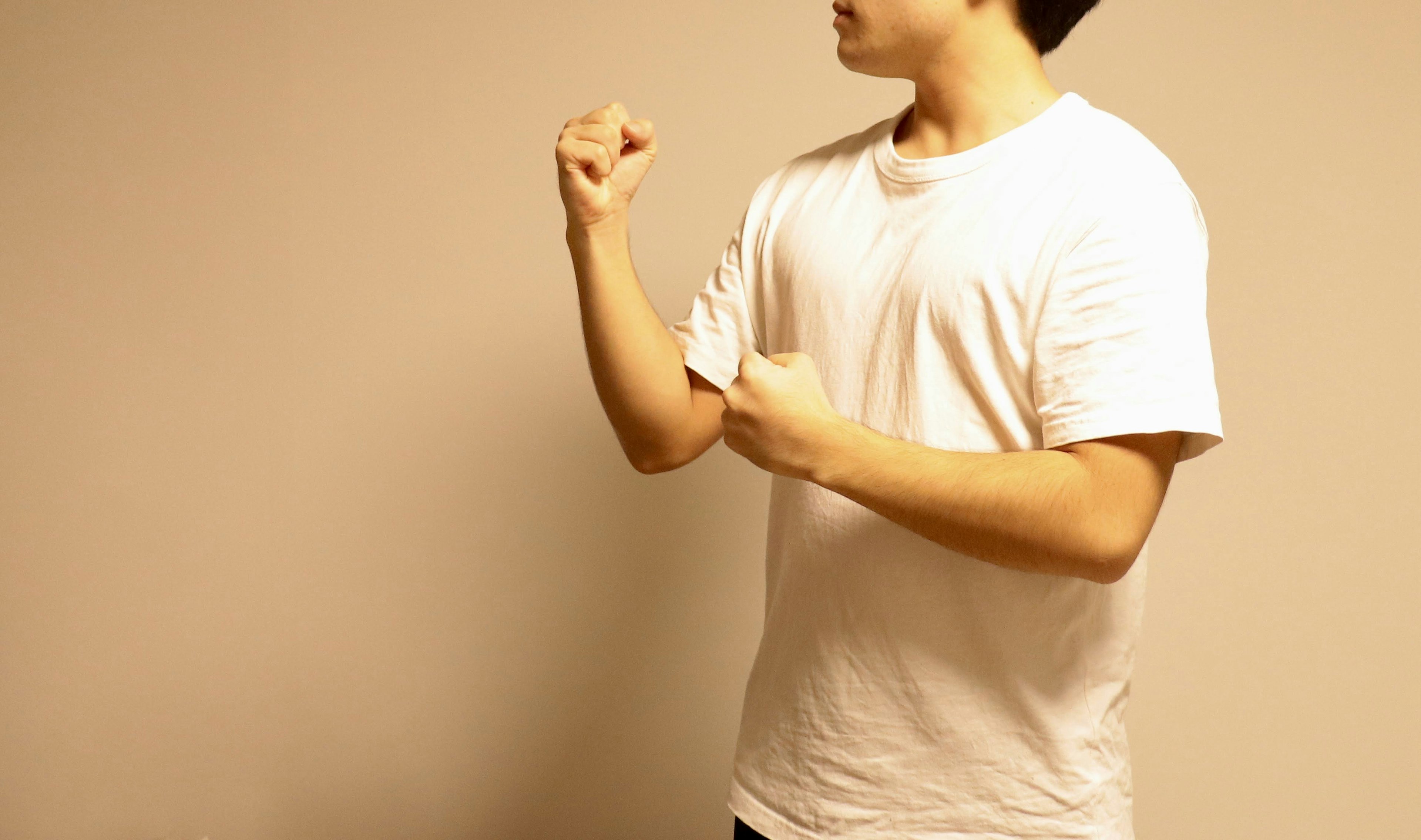 Man in a white t-shirt clenching his fist