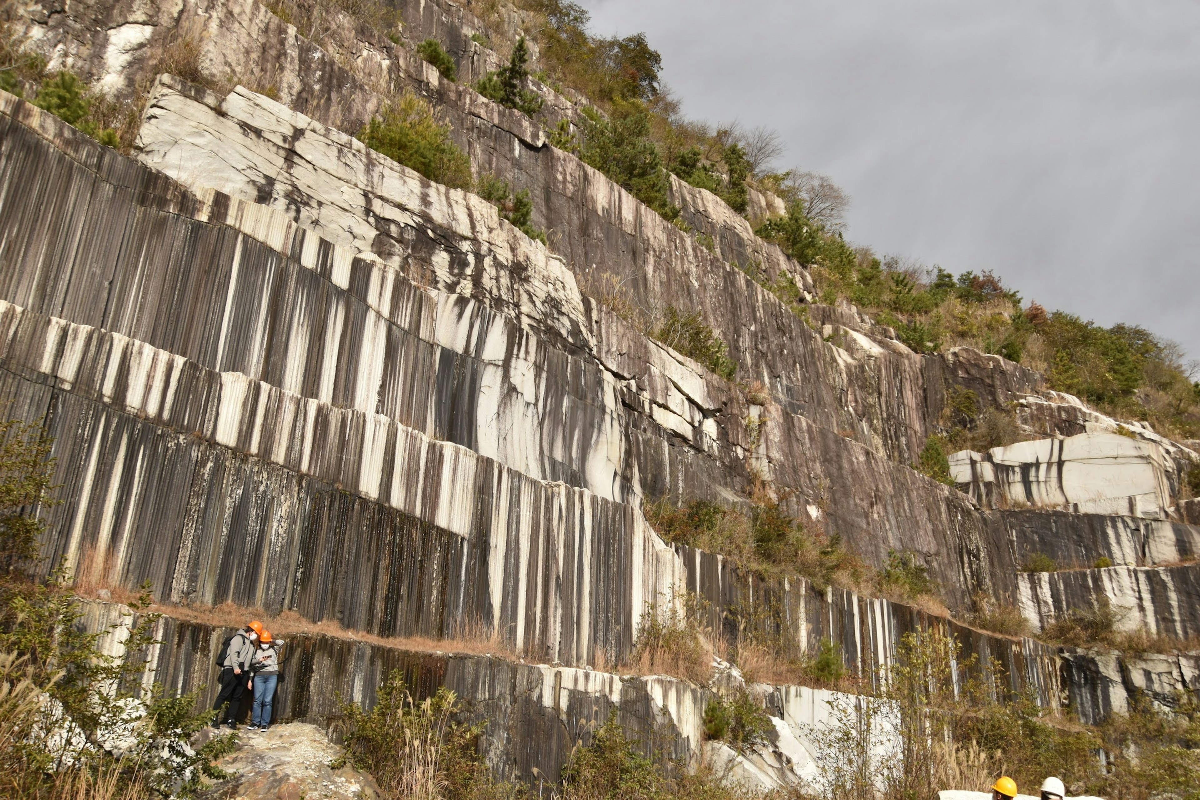 Quarry landscape showing layered rock formations and people