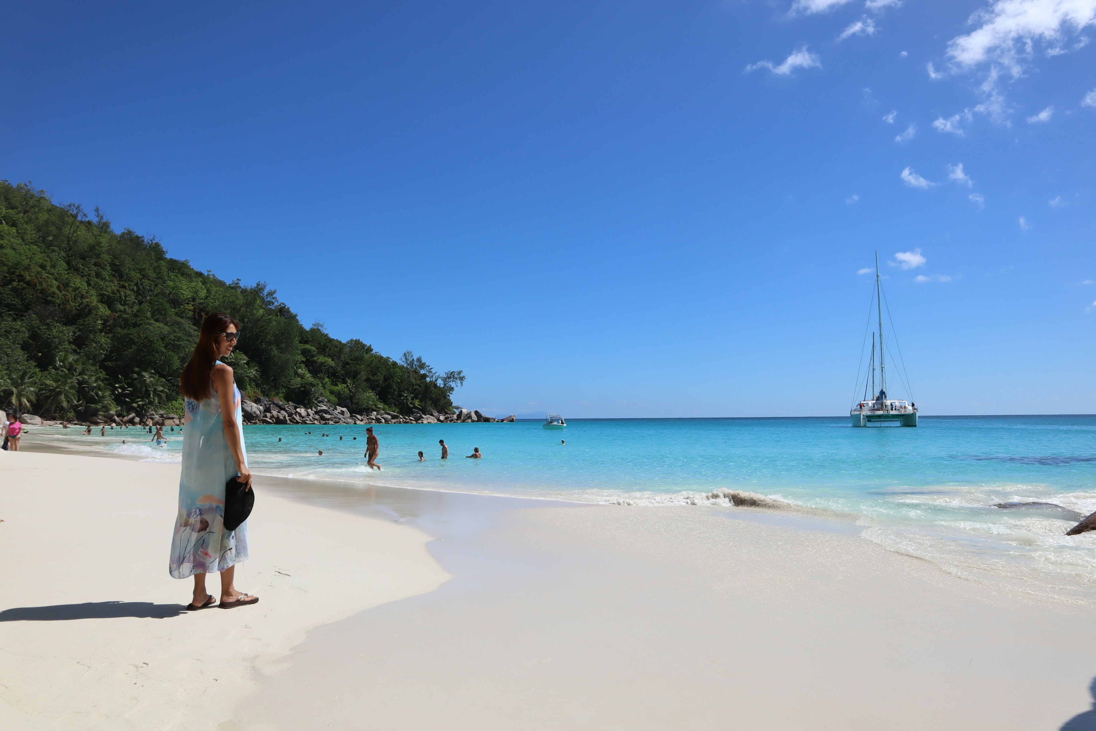 Una donna che si gode una bella spiaggia con acqua e cielo blu chiaro