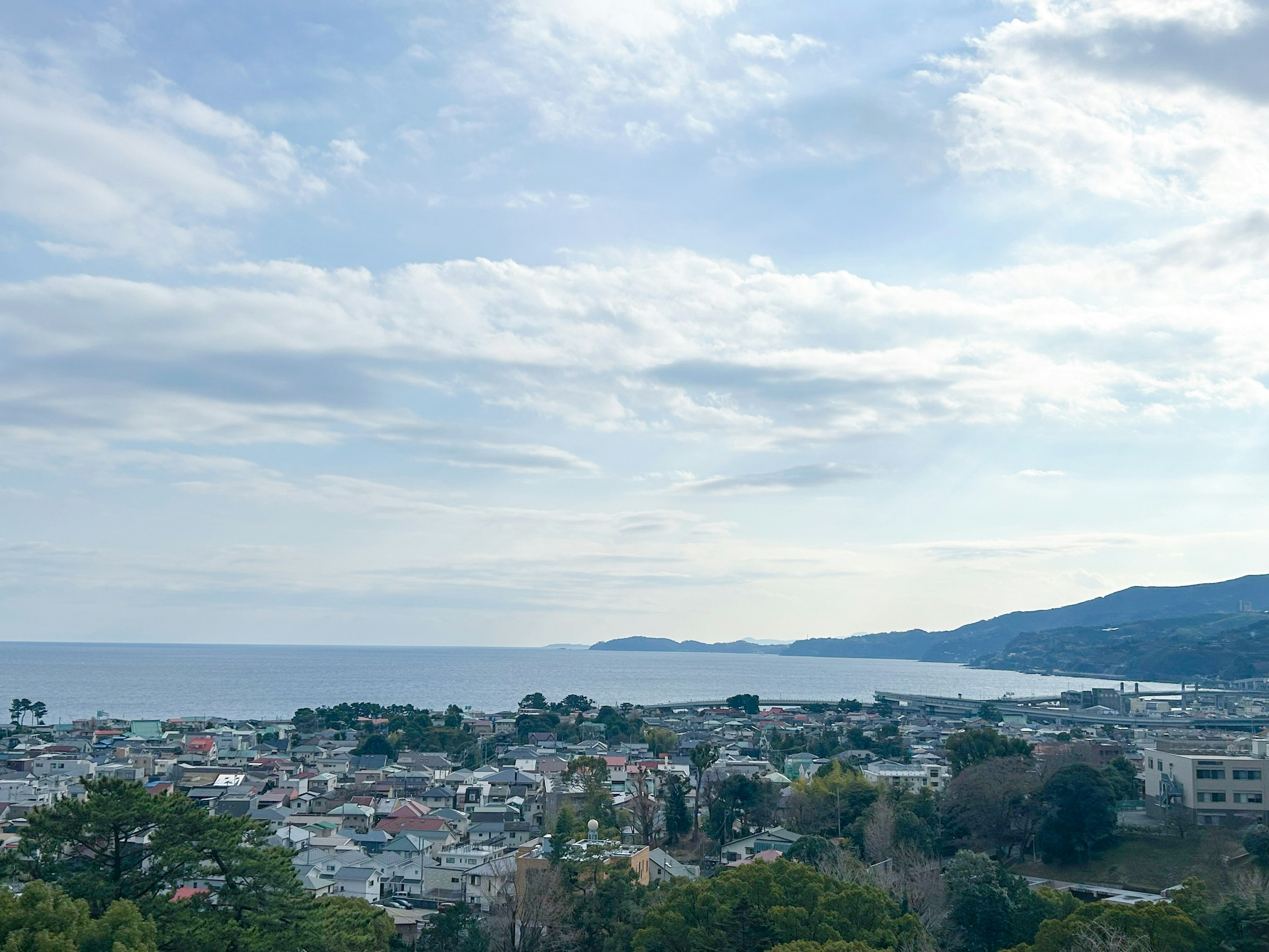 Scenic view of a coastal town under a cloudy sky