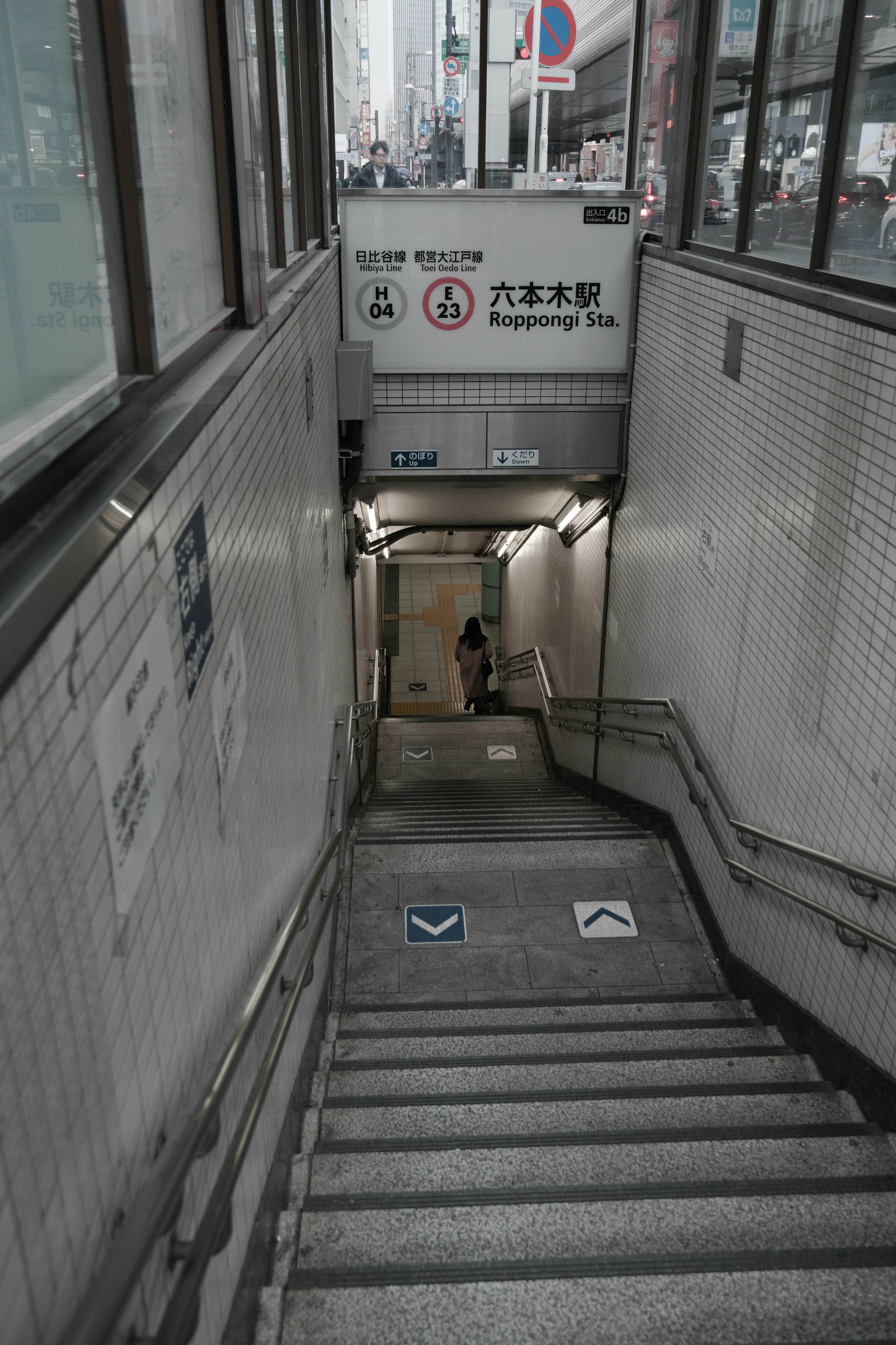 Imagen de escaleras que conducen a una entrada de metro con señalización cercana