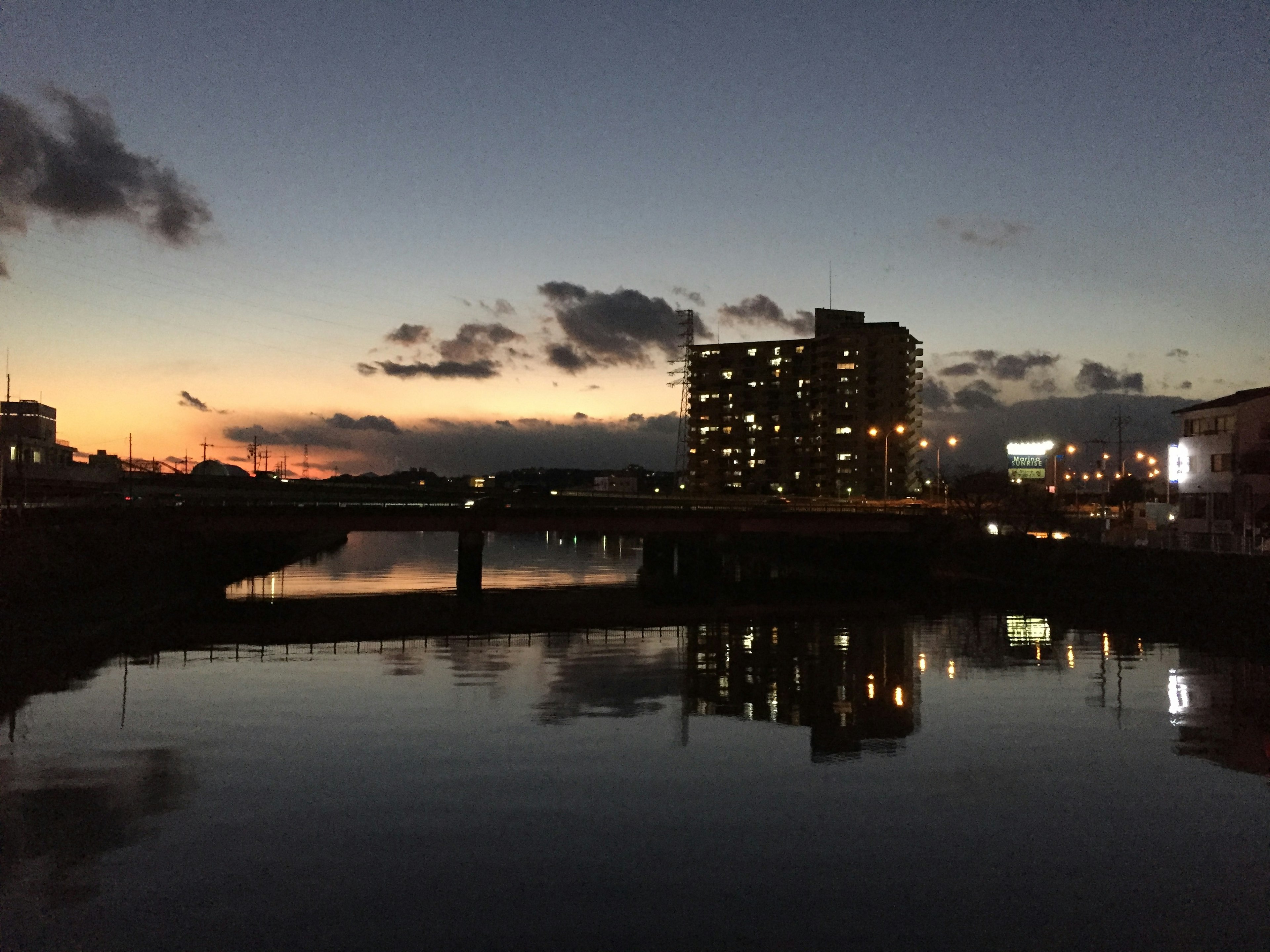 Twilight view of a river and bridge buildings reflecting on the water