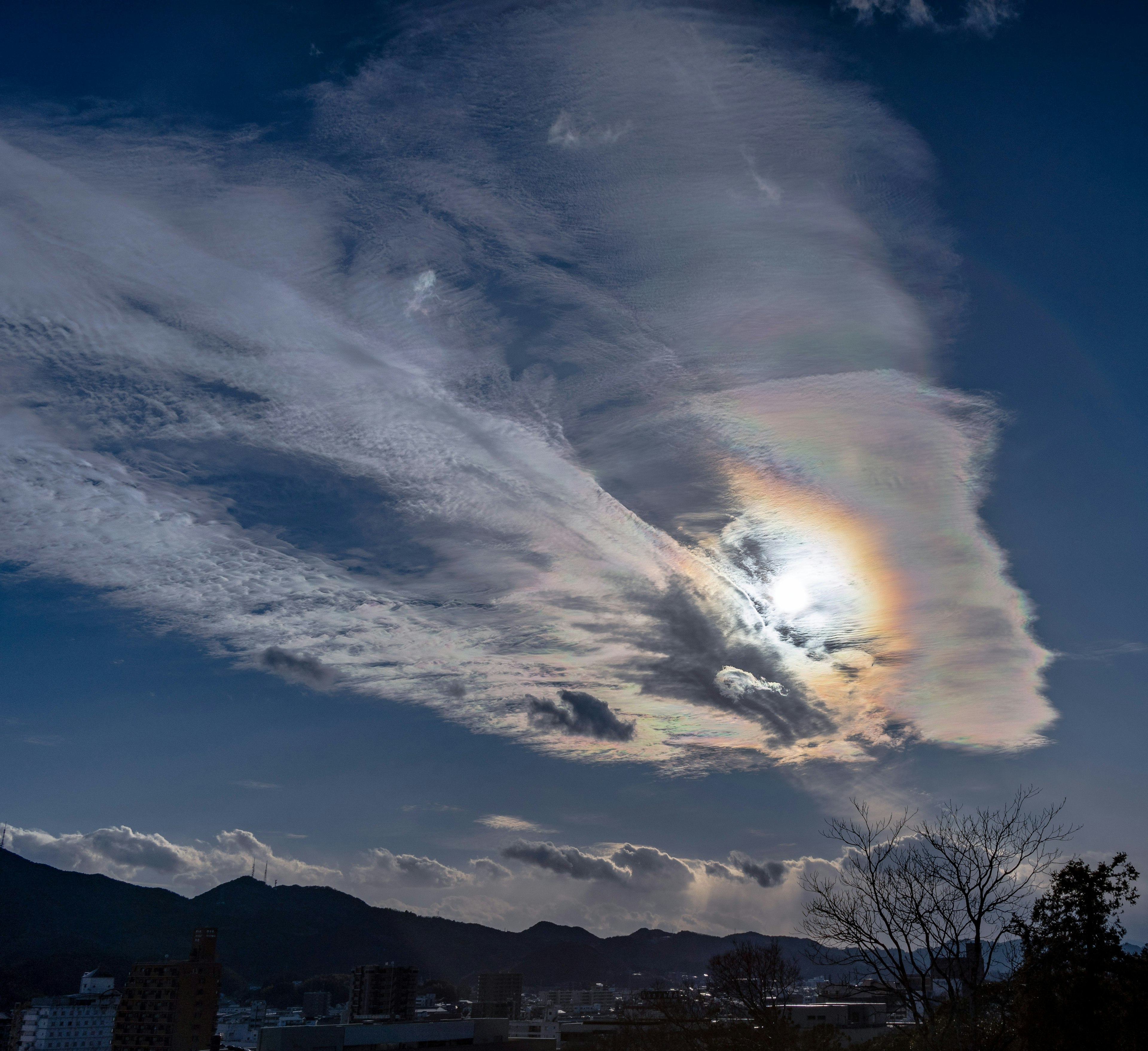 空に広がる雲と太陽の虹色の光の効果