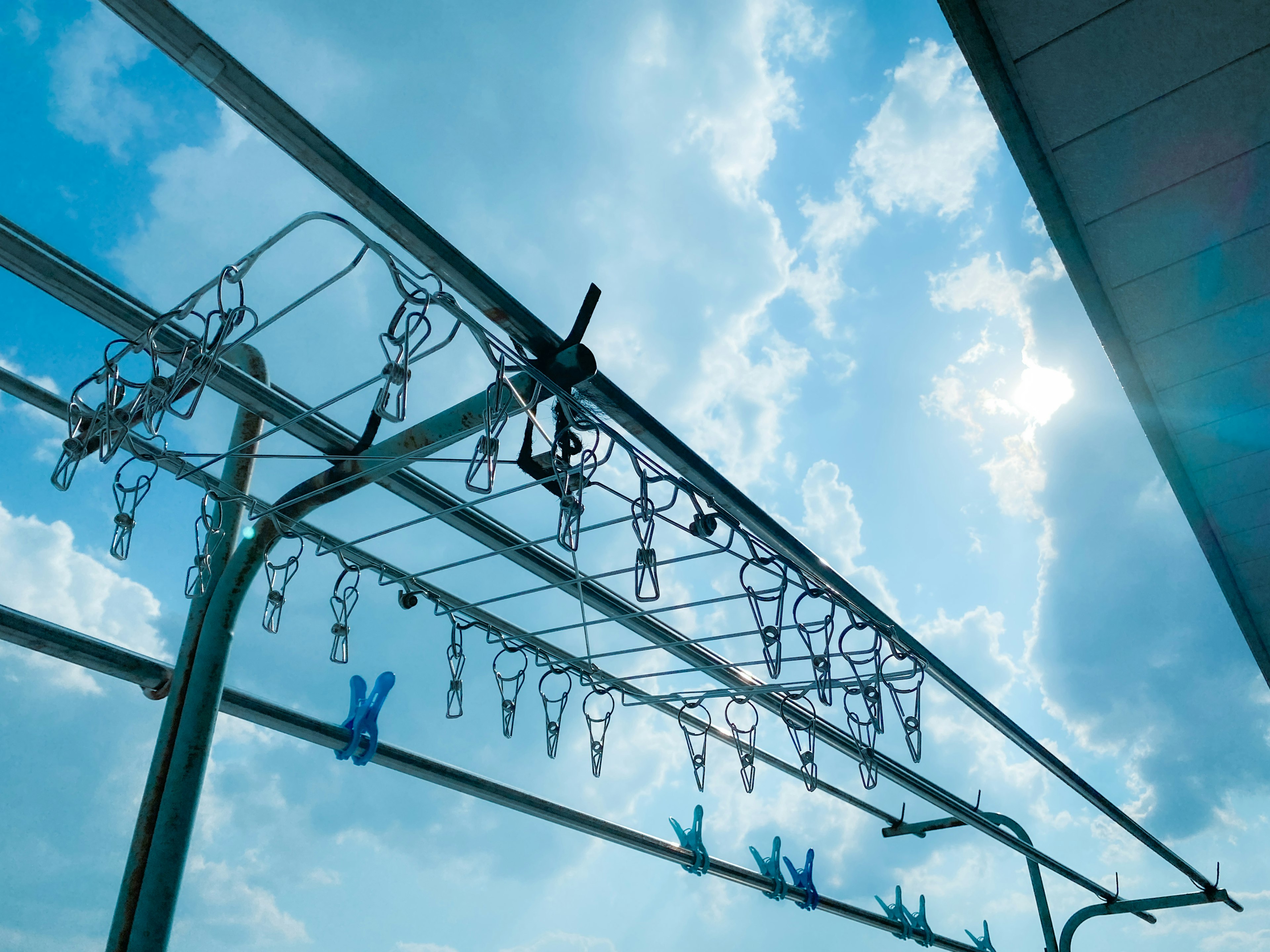 Clothes drying rack under a blue sky with clouds