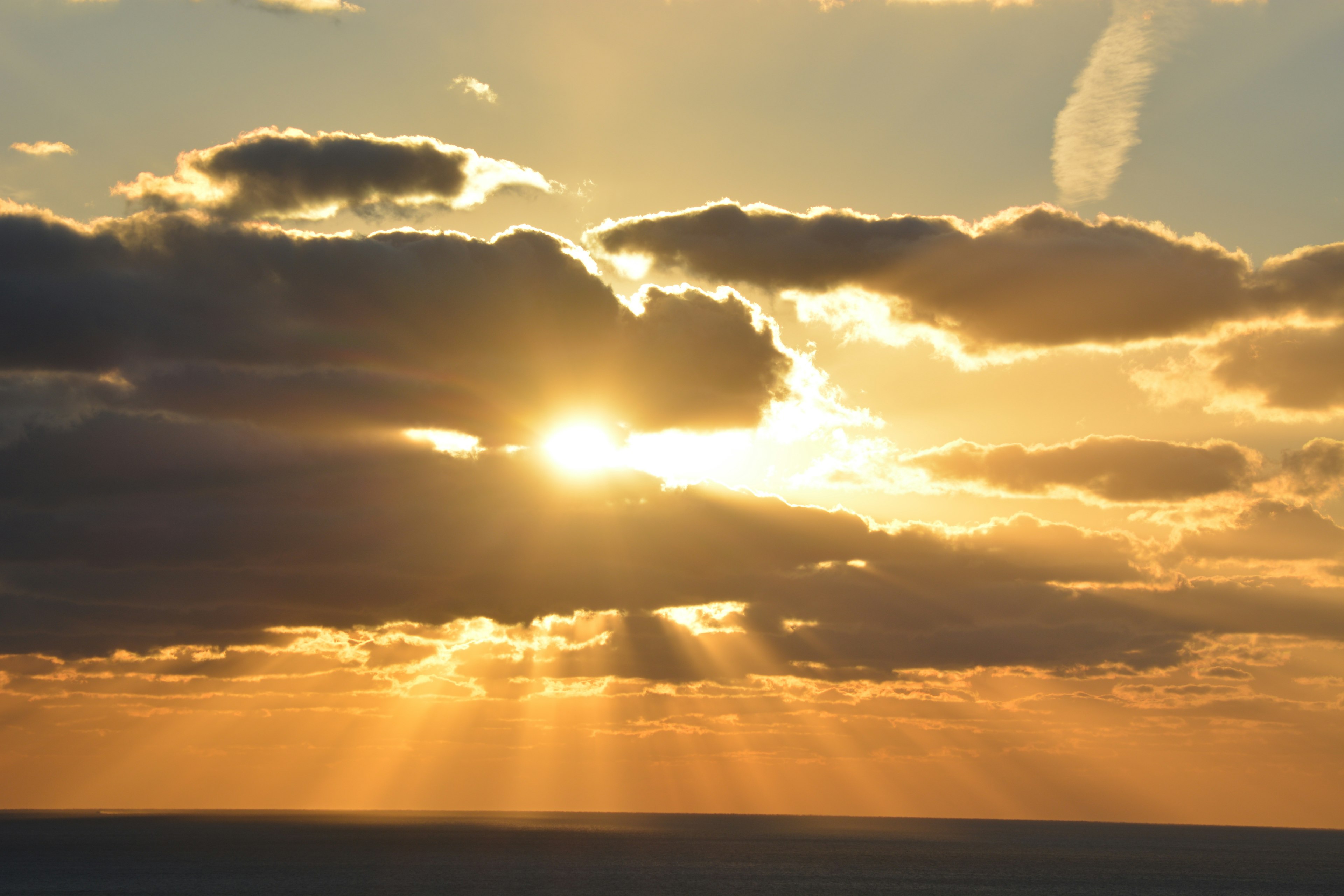 雲の隙間から差し込む太陽の光と美しい夕焼けの空