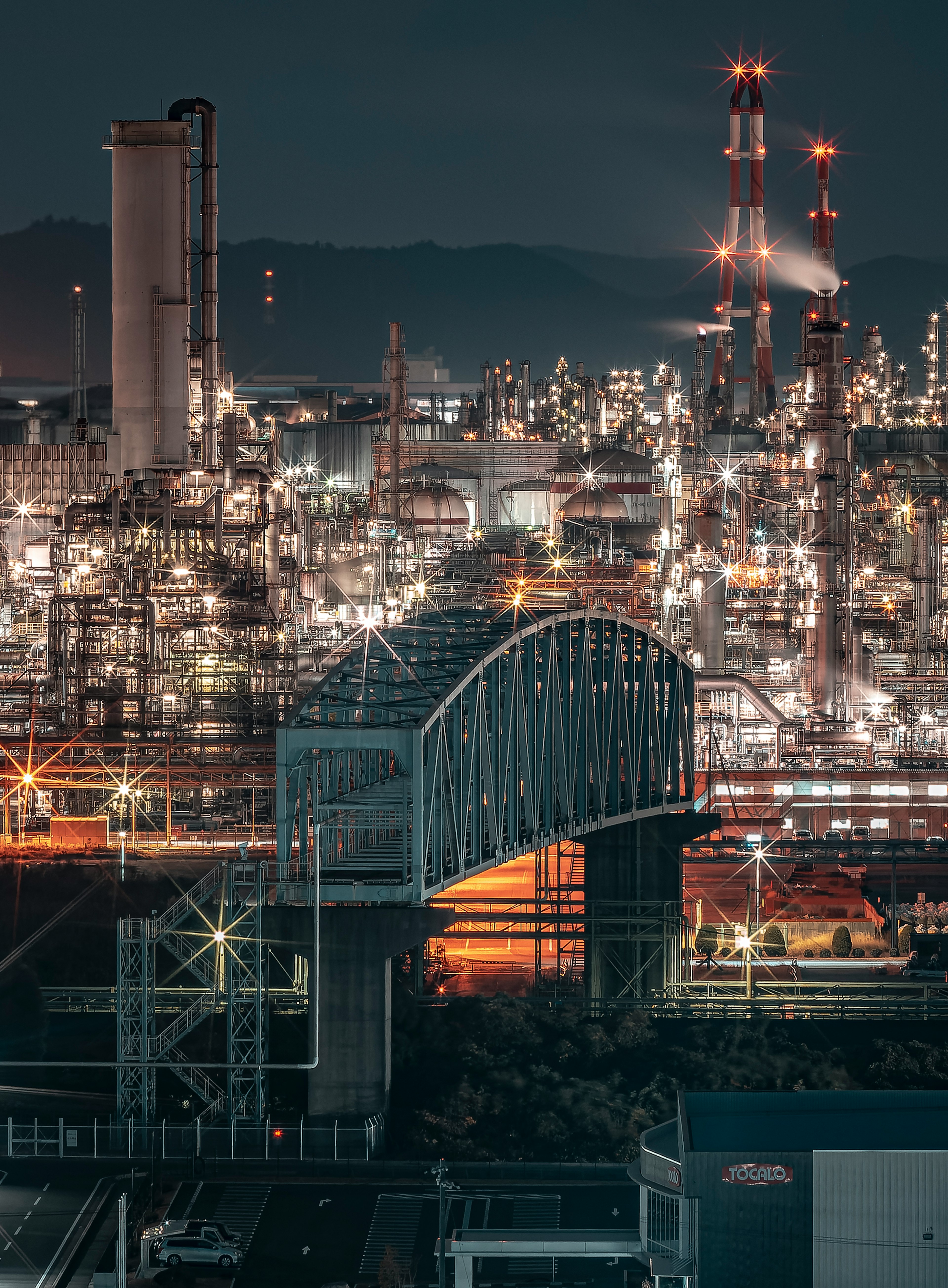 Night view of an industrial area with a bridge and illuminated factories