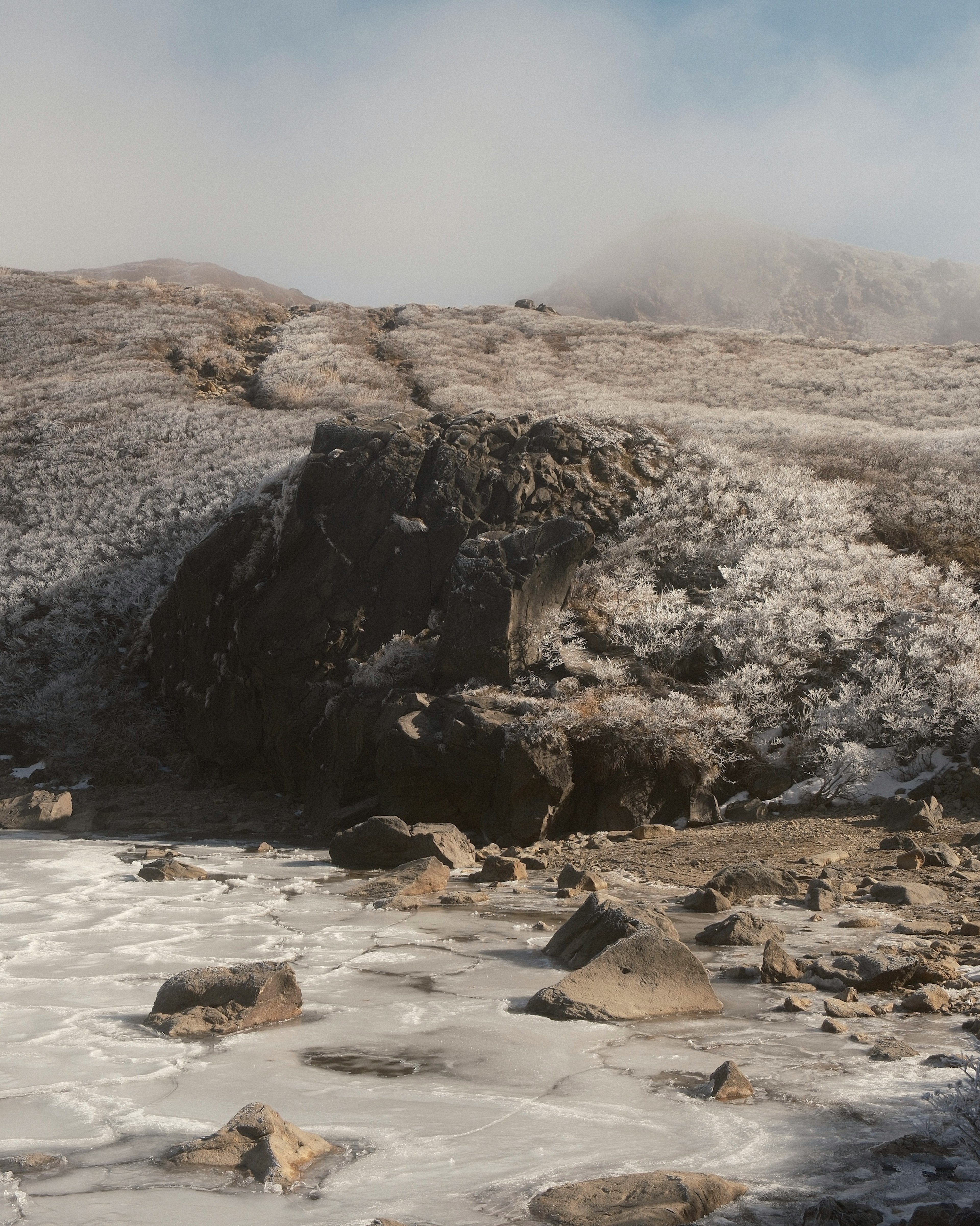 Frozen rocks and mist-covered mountain landscape