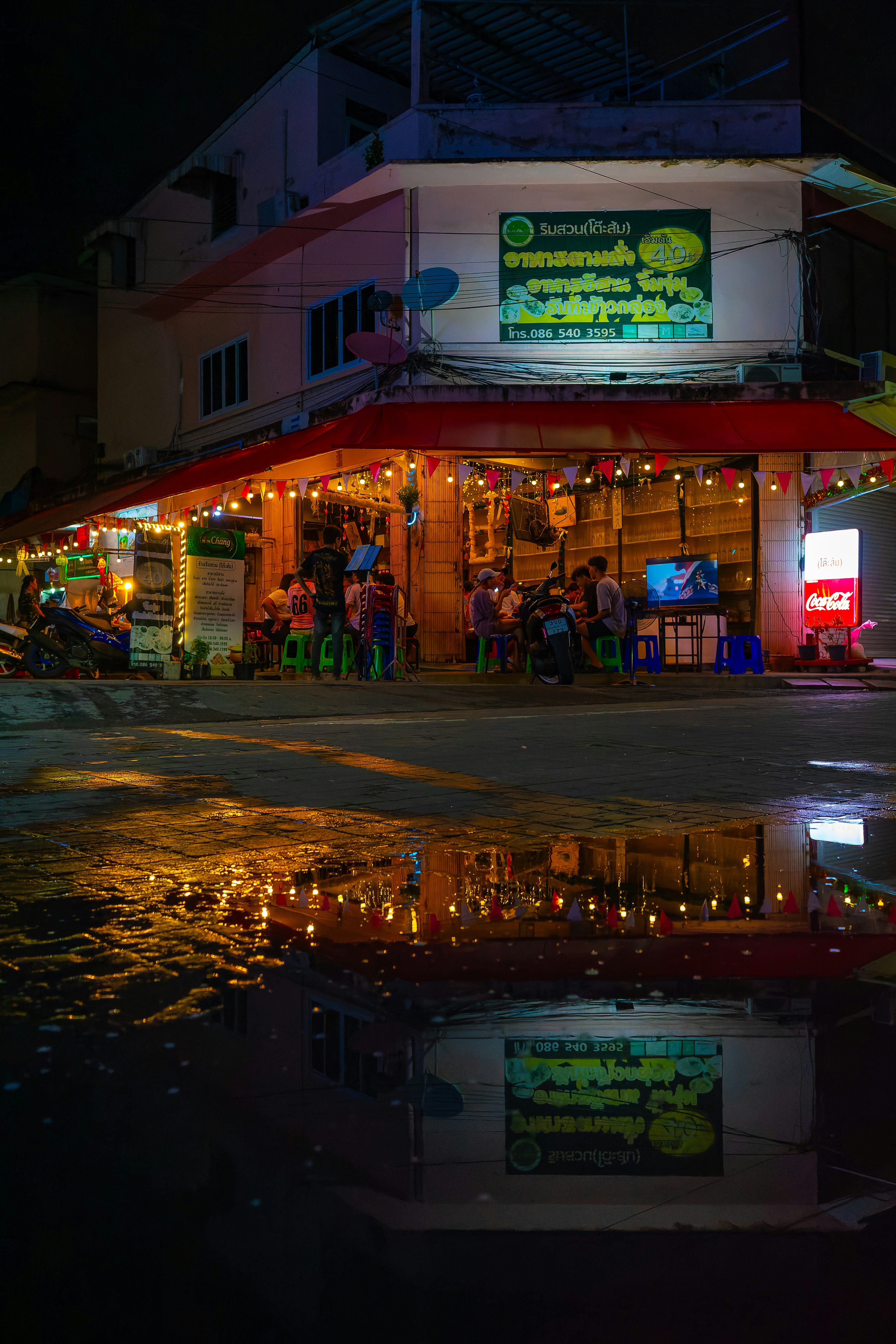 Escena nocturna vibrante de un mercado callejero con reflejos en el agua