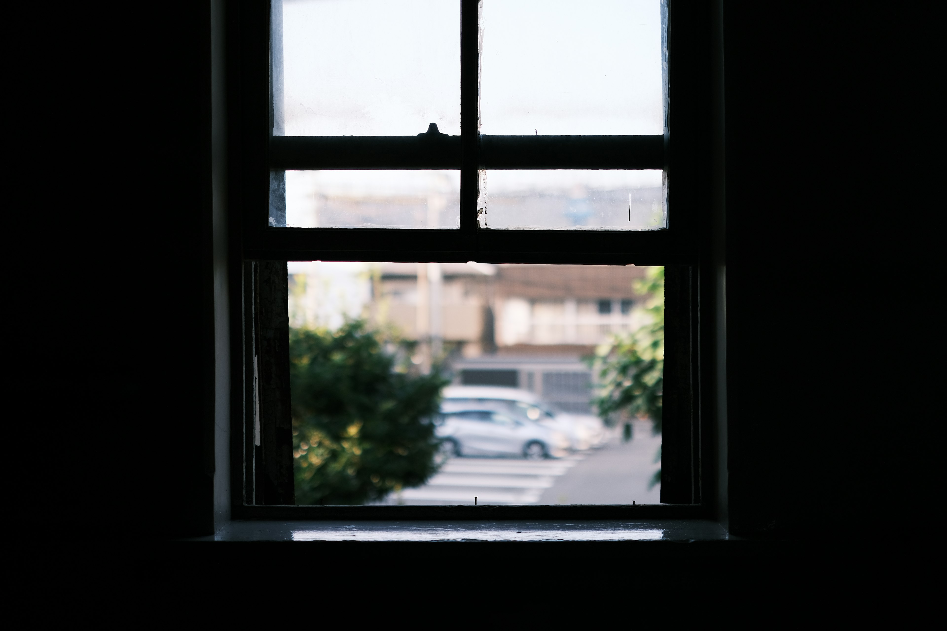 Blurred view of an outdoor scene and car through a window