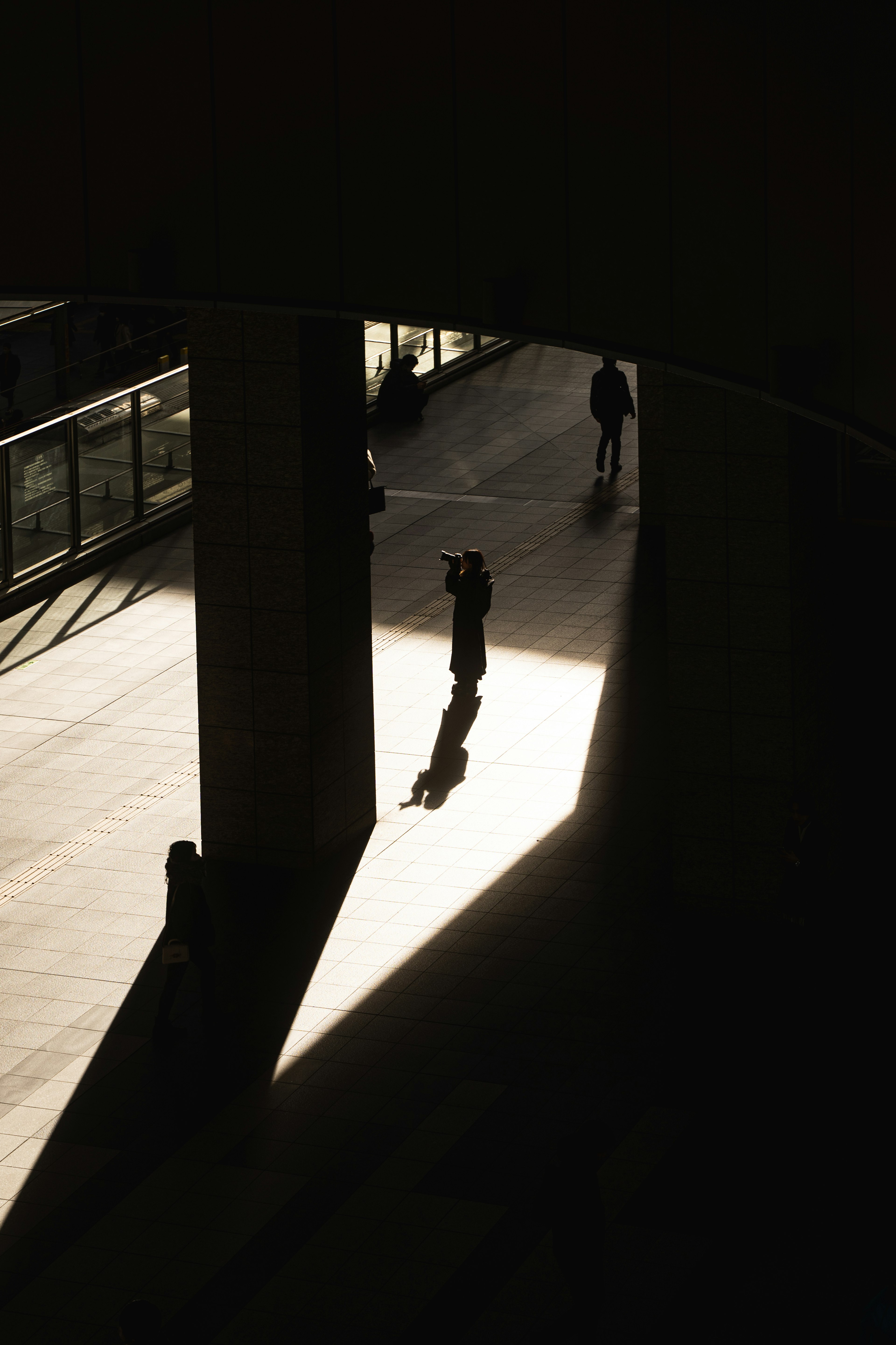 Silhouette of a person walking in a dark corridor with long shadows