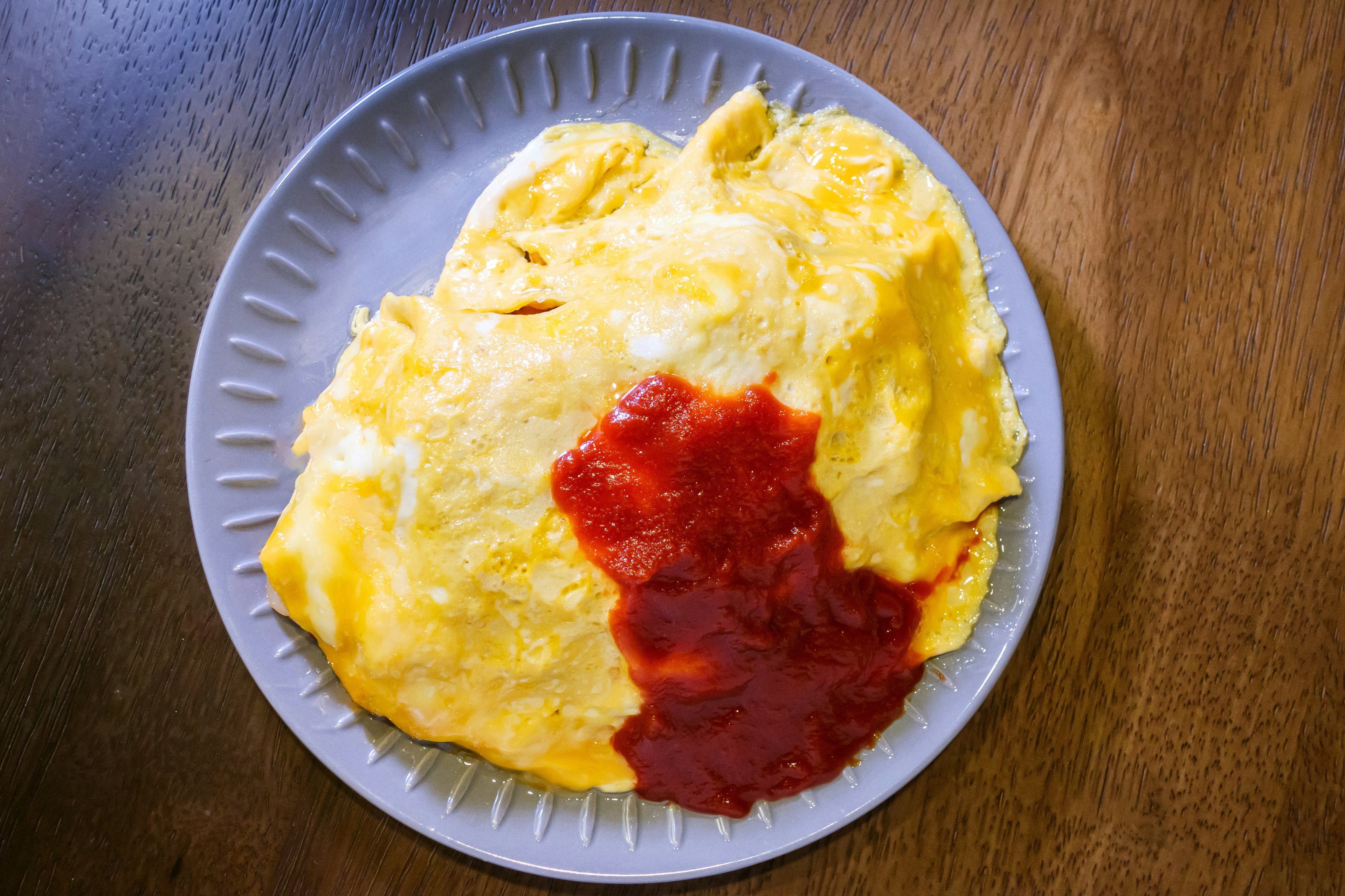 Omelett mit Ketchup auf einem Teller serviert