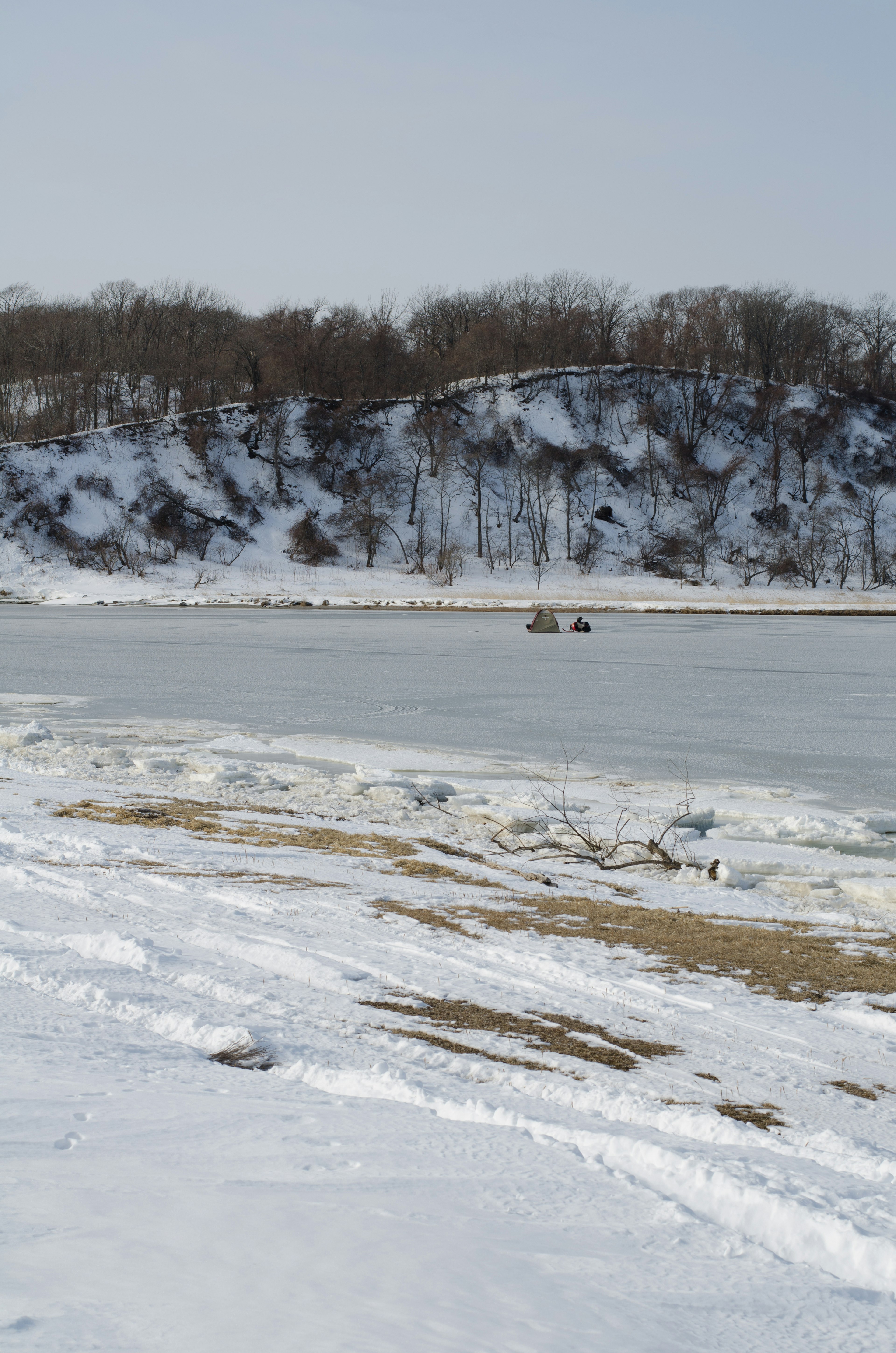 Schneebedeckte Ufer mit einem gefrorenen Fluss