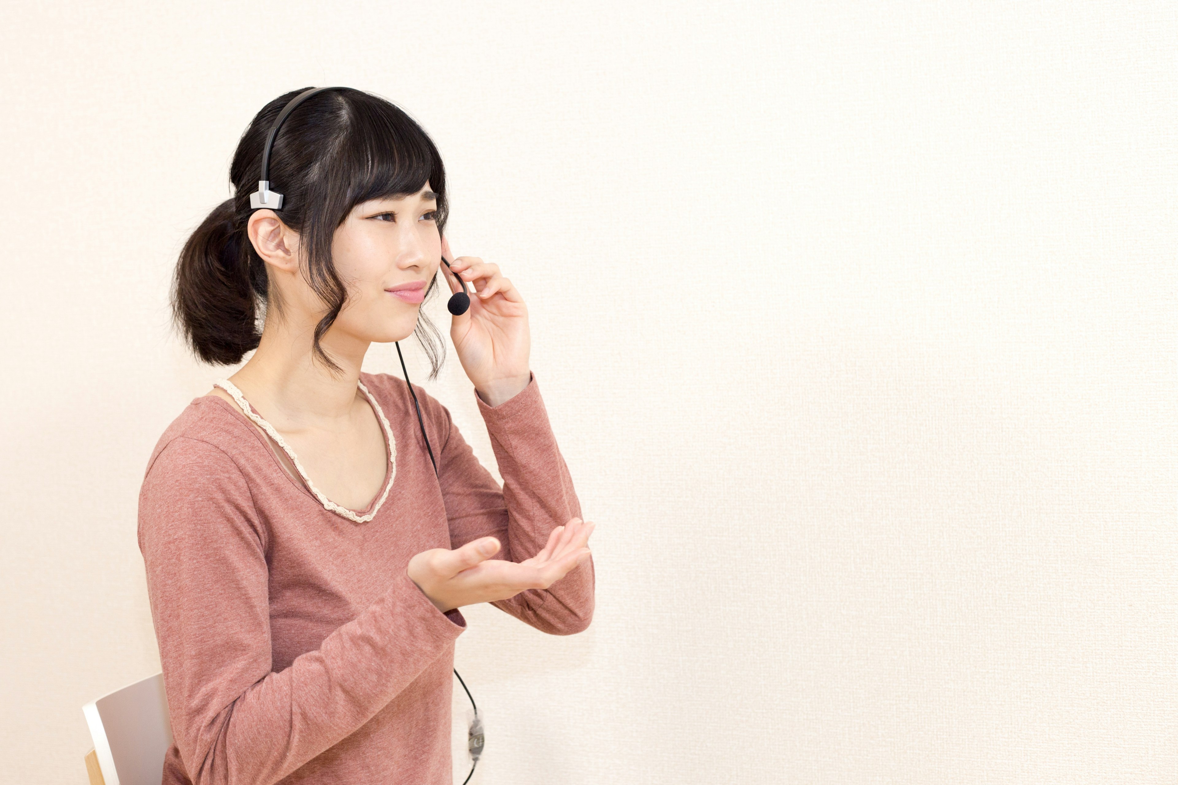 Side view of a woman speaking while wearing a headset