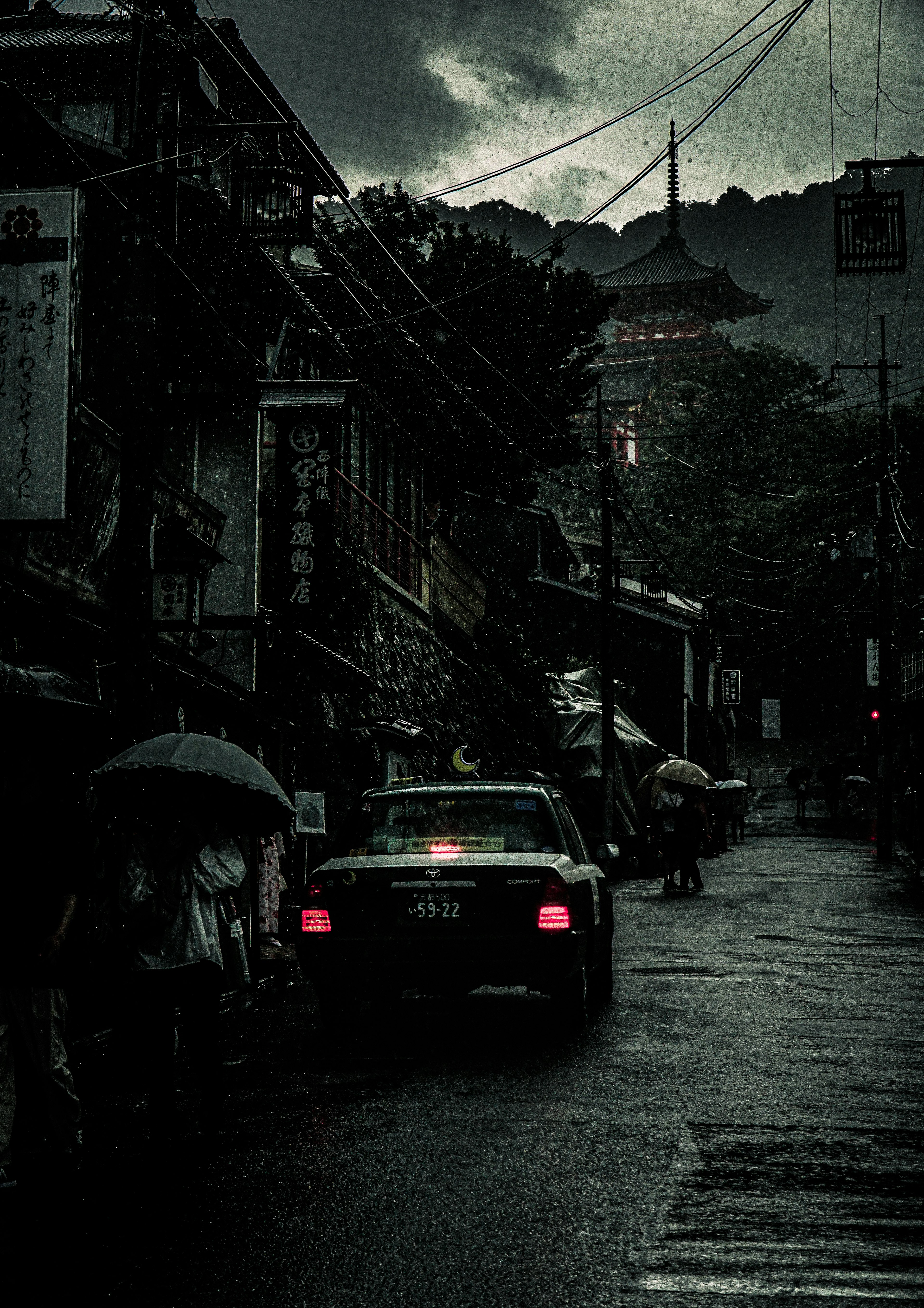 暗い雲に覆われた街並みと車両が見える雨の日の風景