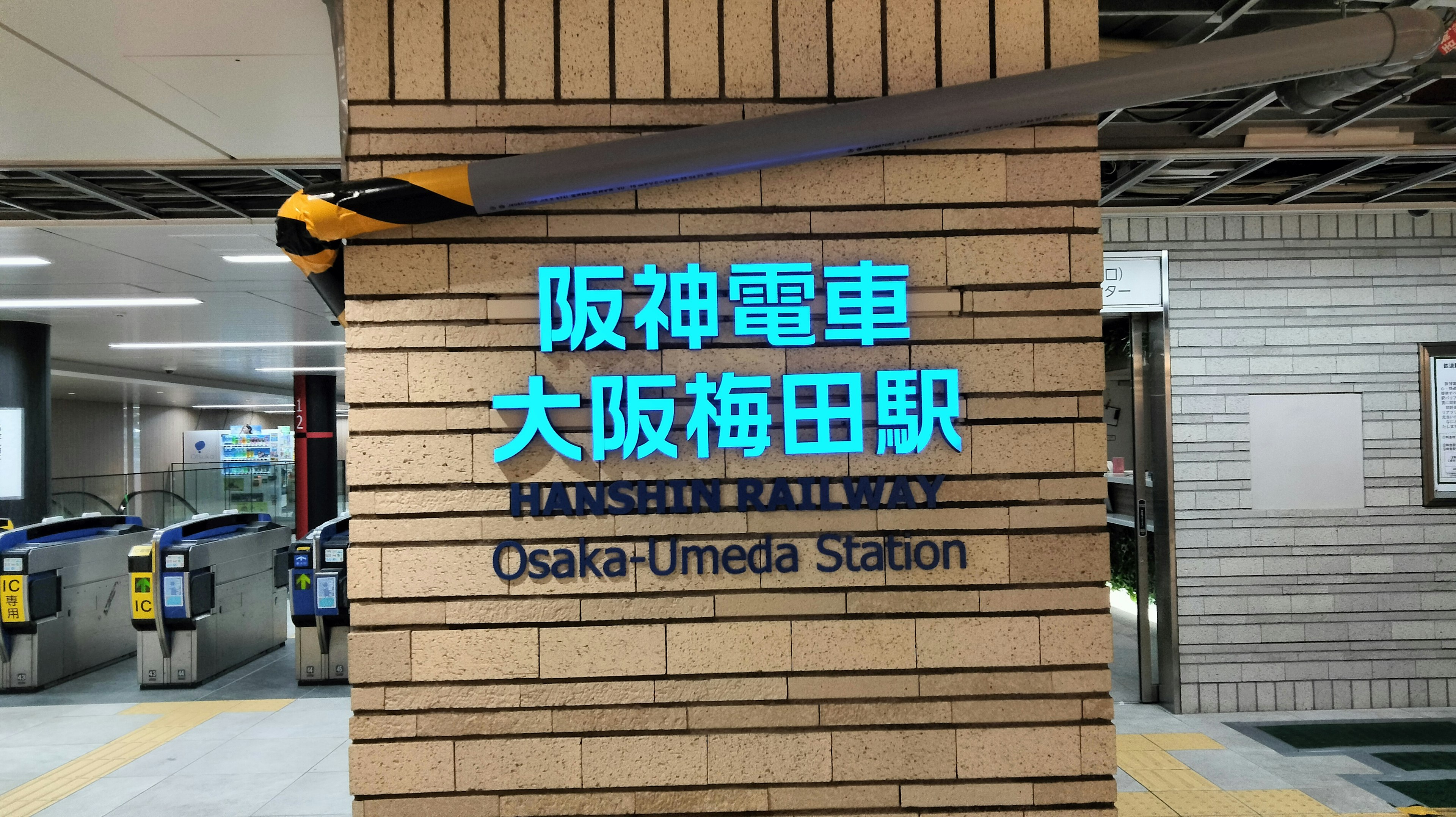 大阪梅田駅の看板で、阪神電車のロゴが青色で表示されています