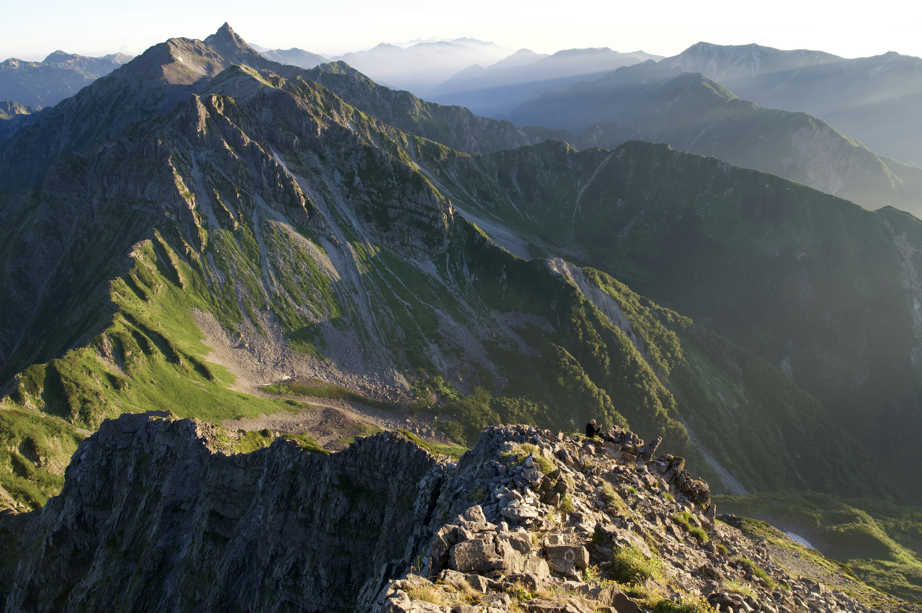 Vista panoramica di montagne con pendii verdi e formazioni rocciose