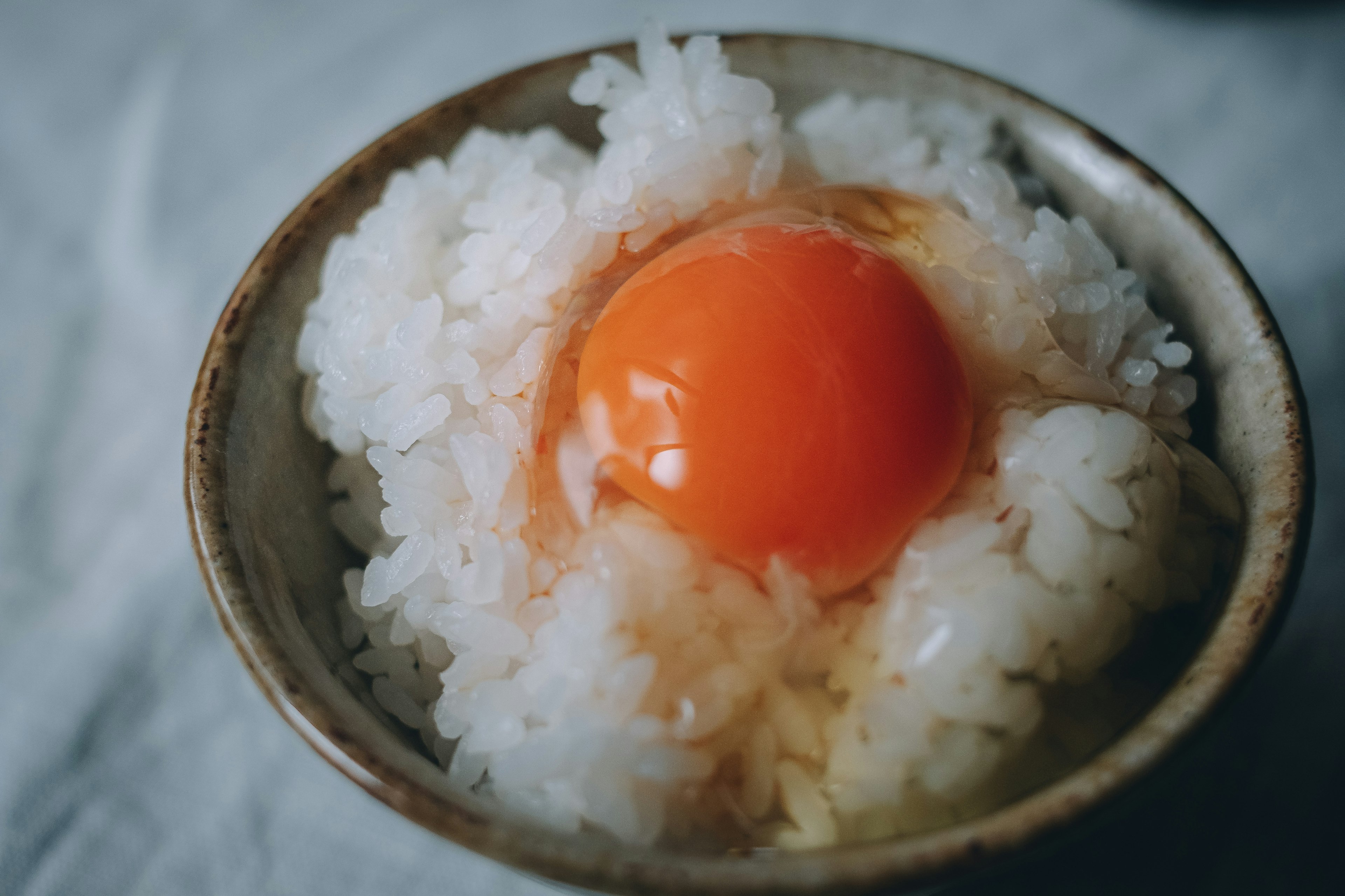 Un tazón de arroz cubierto con una yema de huevo vibrante