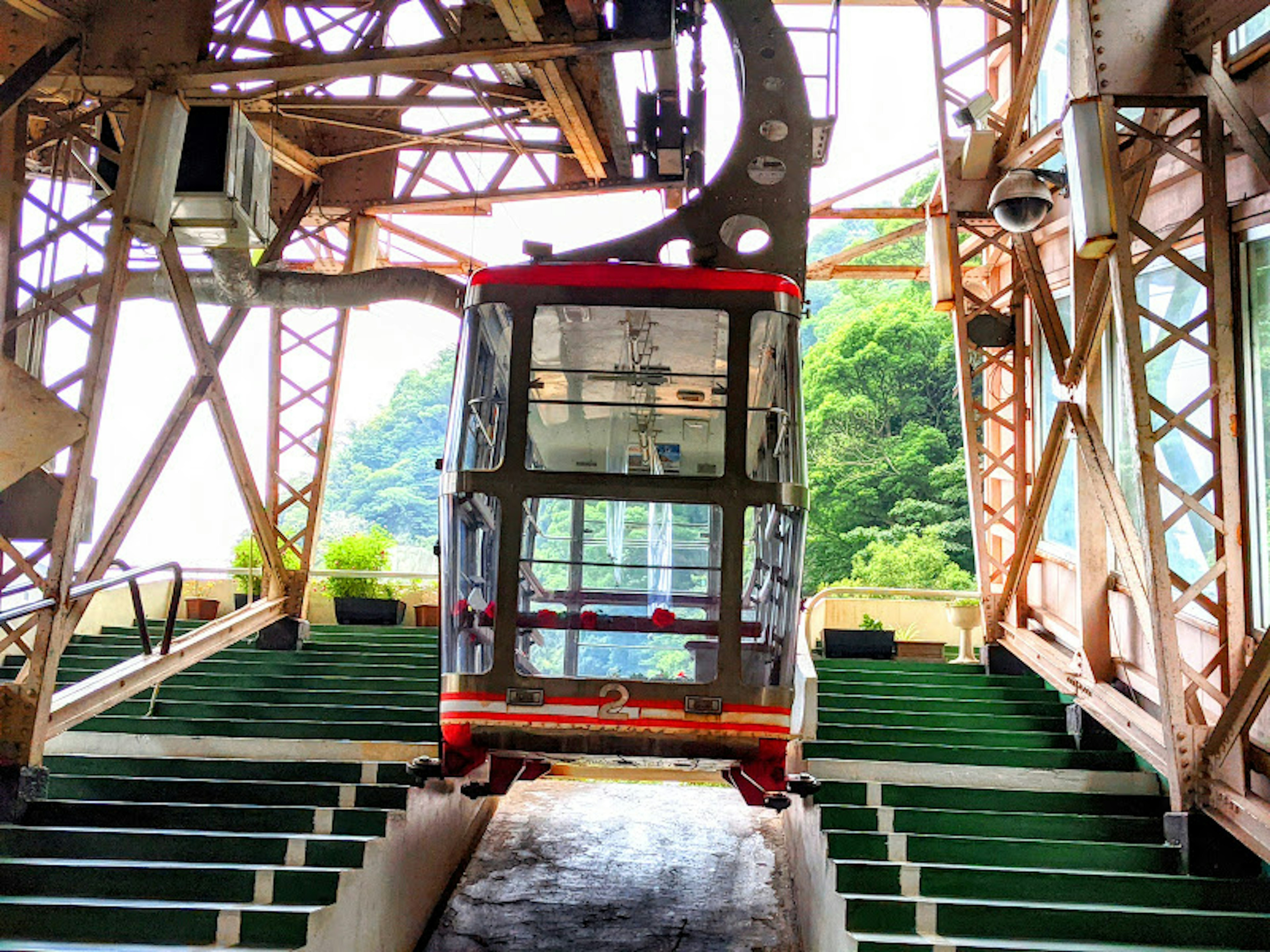 Interior view of a cable car station featuring green benches and metal structure