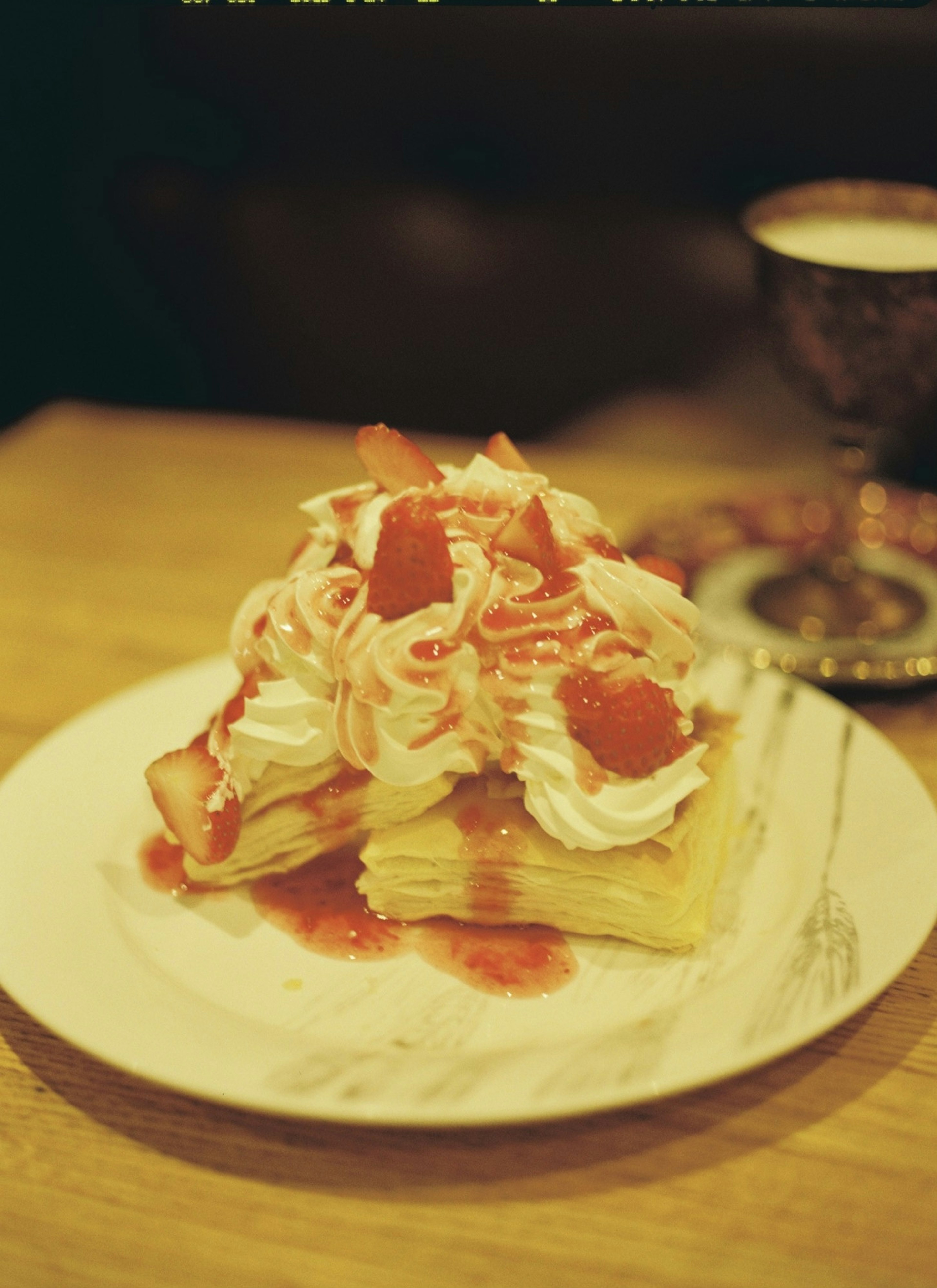 Kue mille-feuille yang dihiasi dengan krim dan saus stroberi