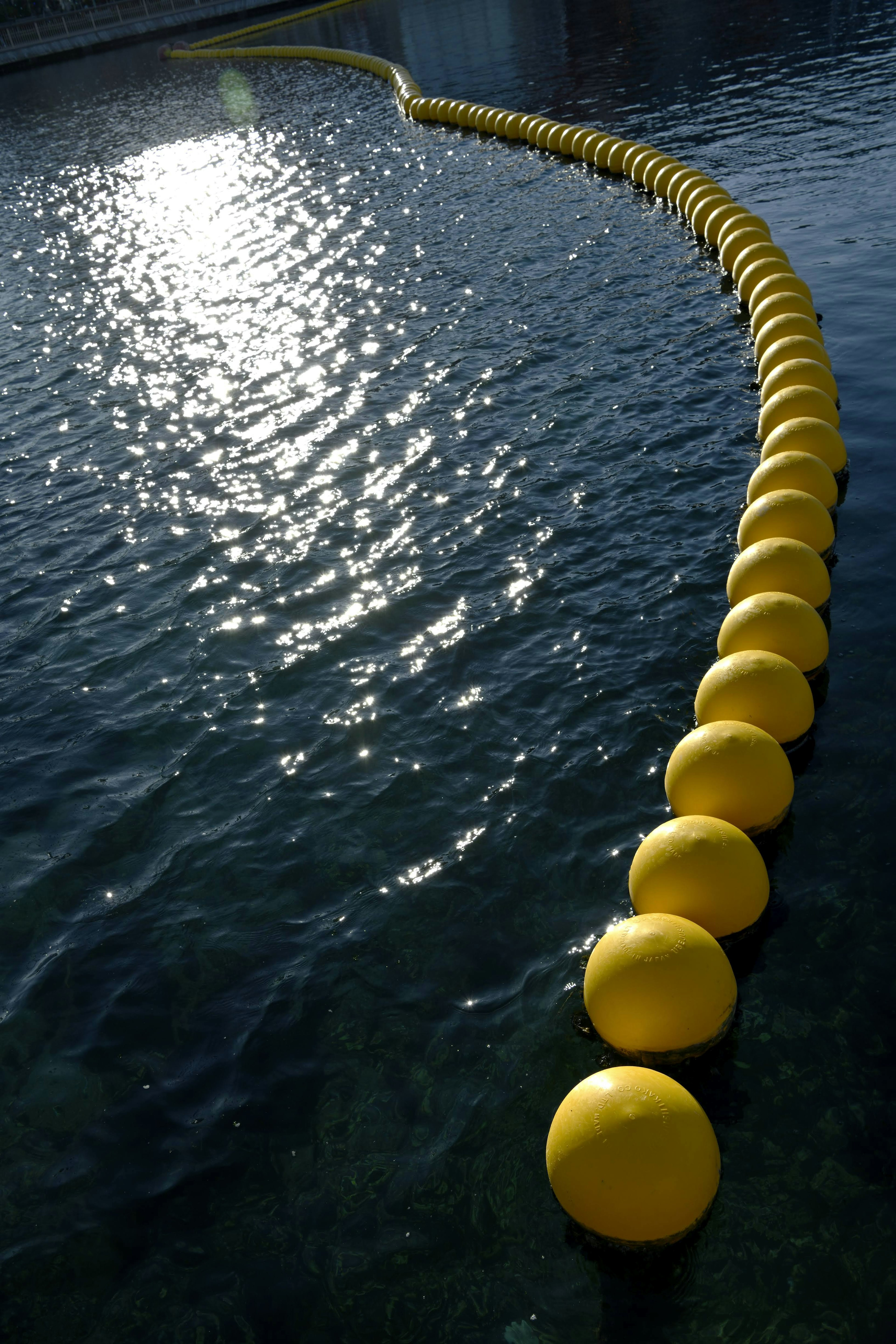 Una serie de boyas amarillas flotando en la superficie del agua