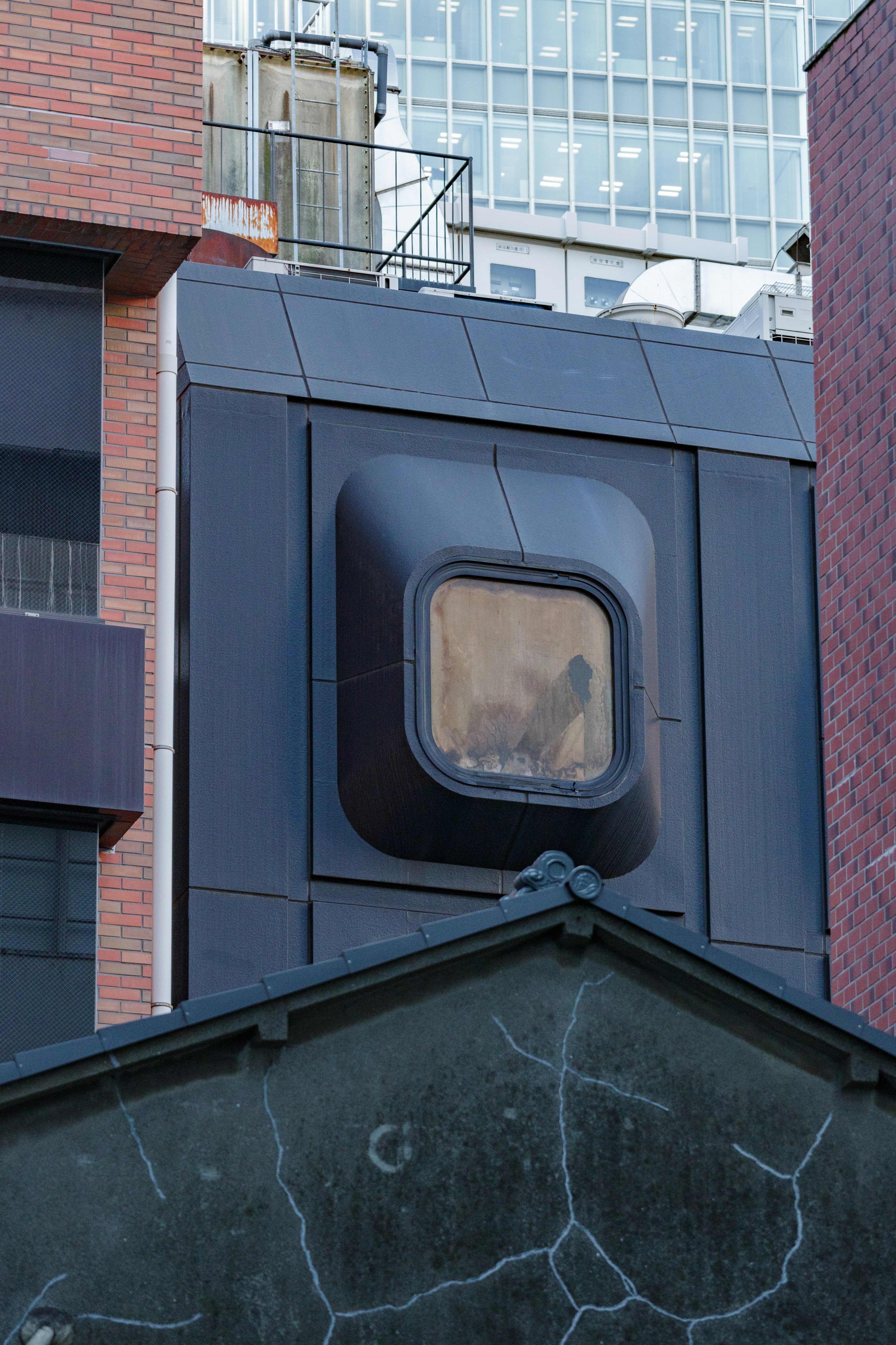 Ventana de forma única en un edificio moderno con estructuras circundantes