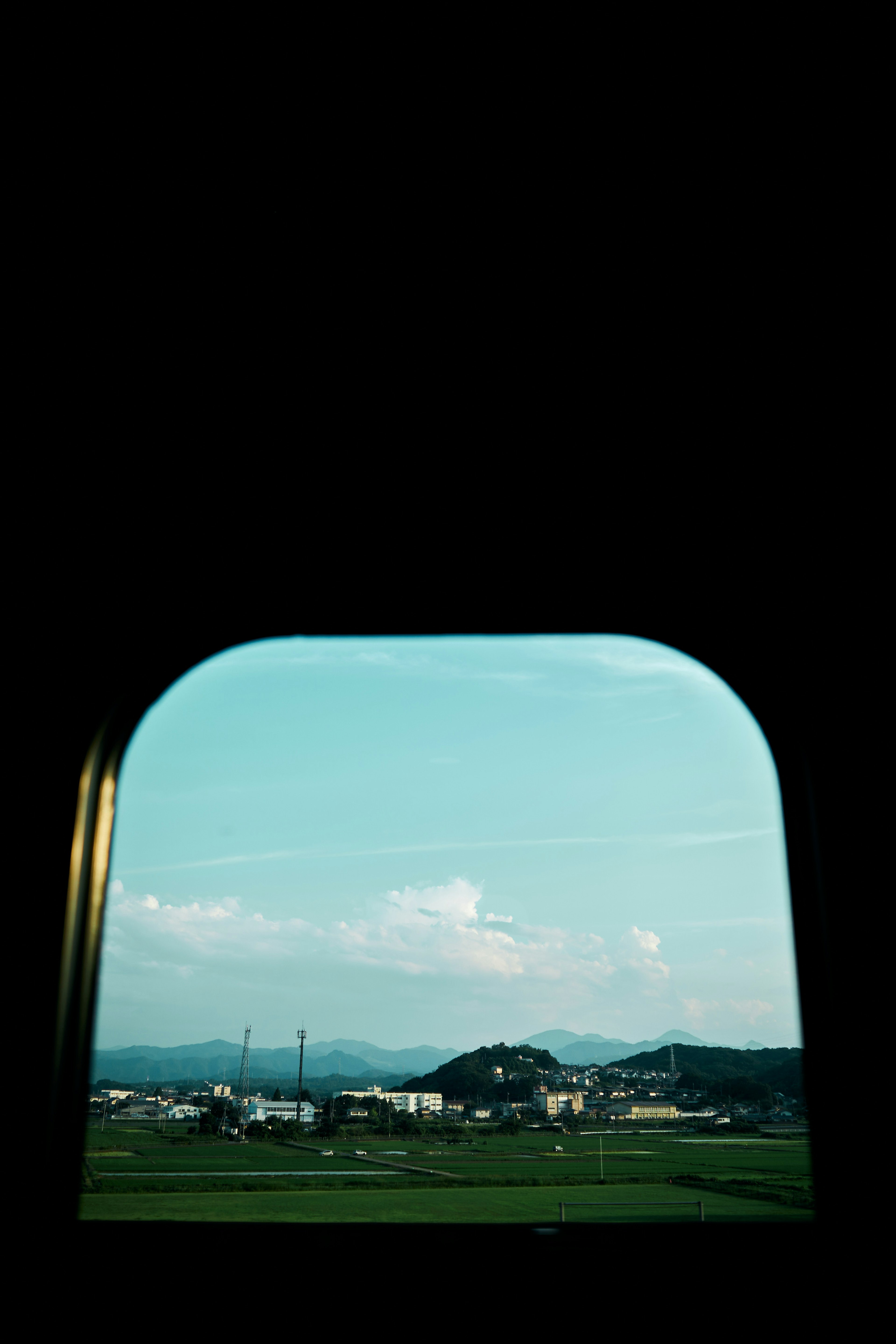 青空と山々を背景にした窓からの風景