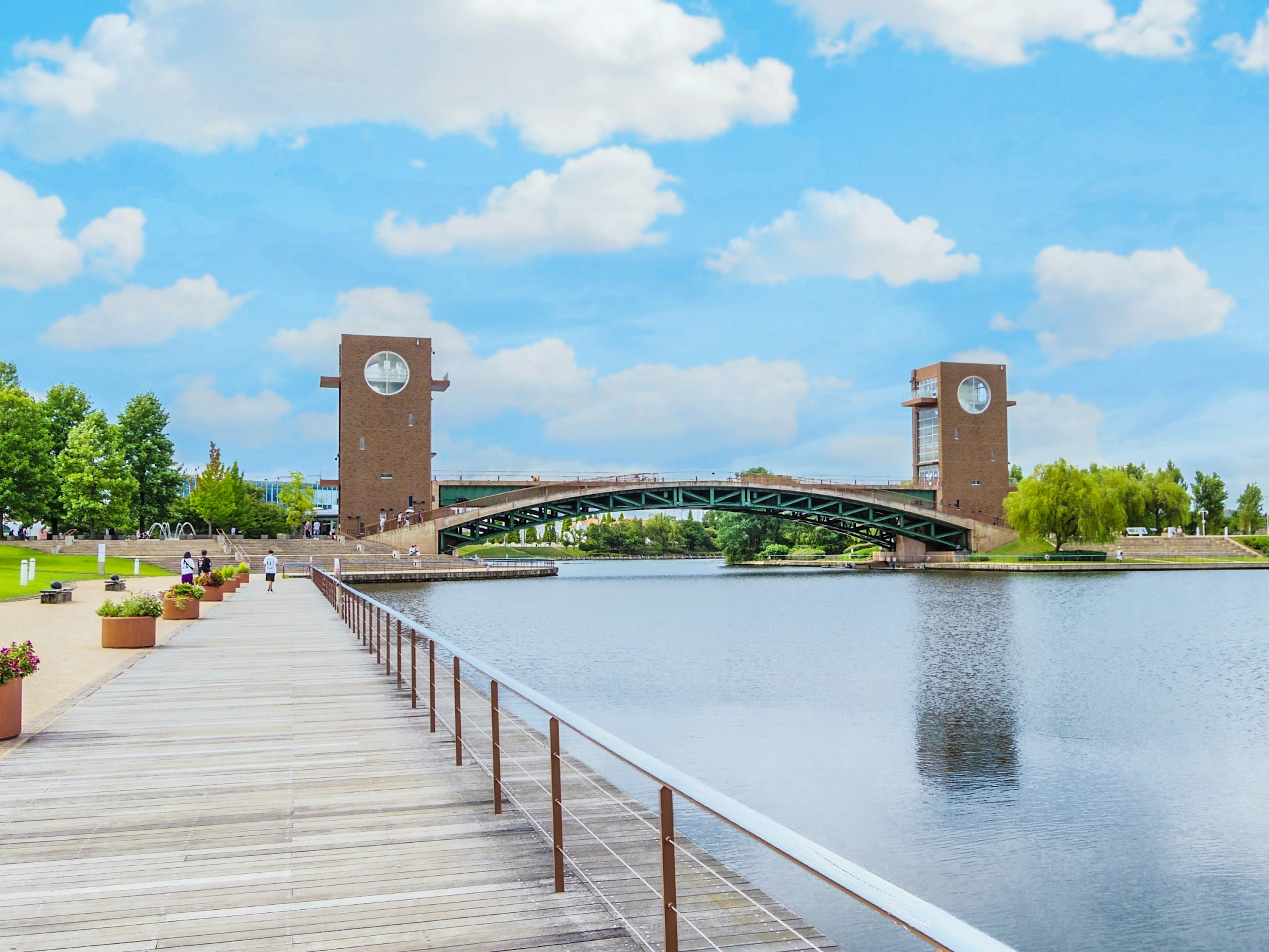 Malersiche Aussicht auf eine Brücke und Uhrentürme über einem ruhigen Gewässer unter einem blauen Himmel