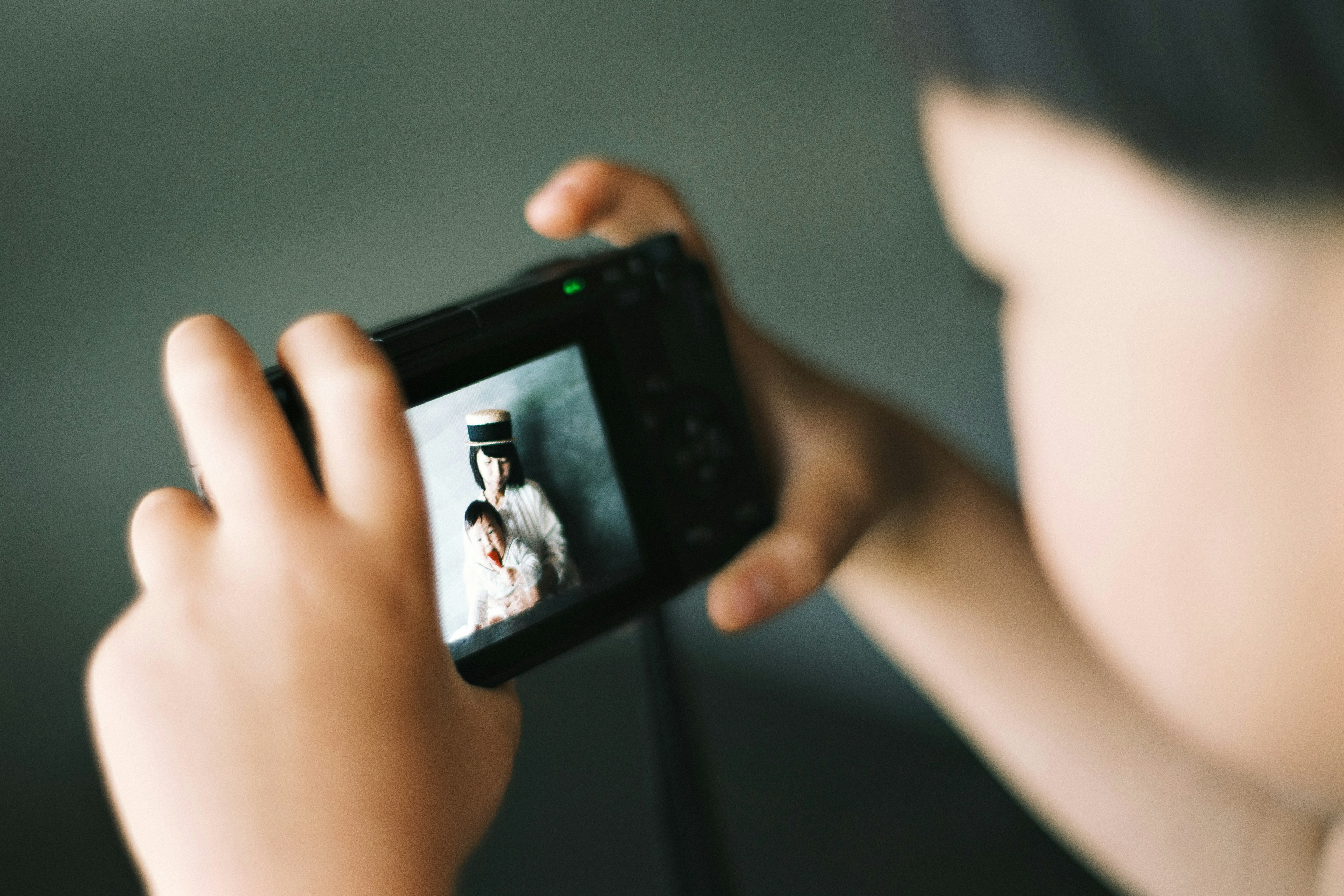 Bambino che tiene una macchina fotografica e scatta una foto