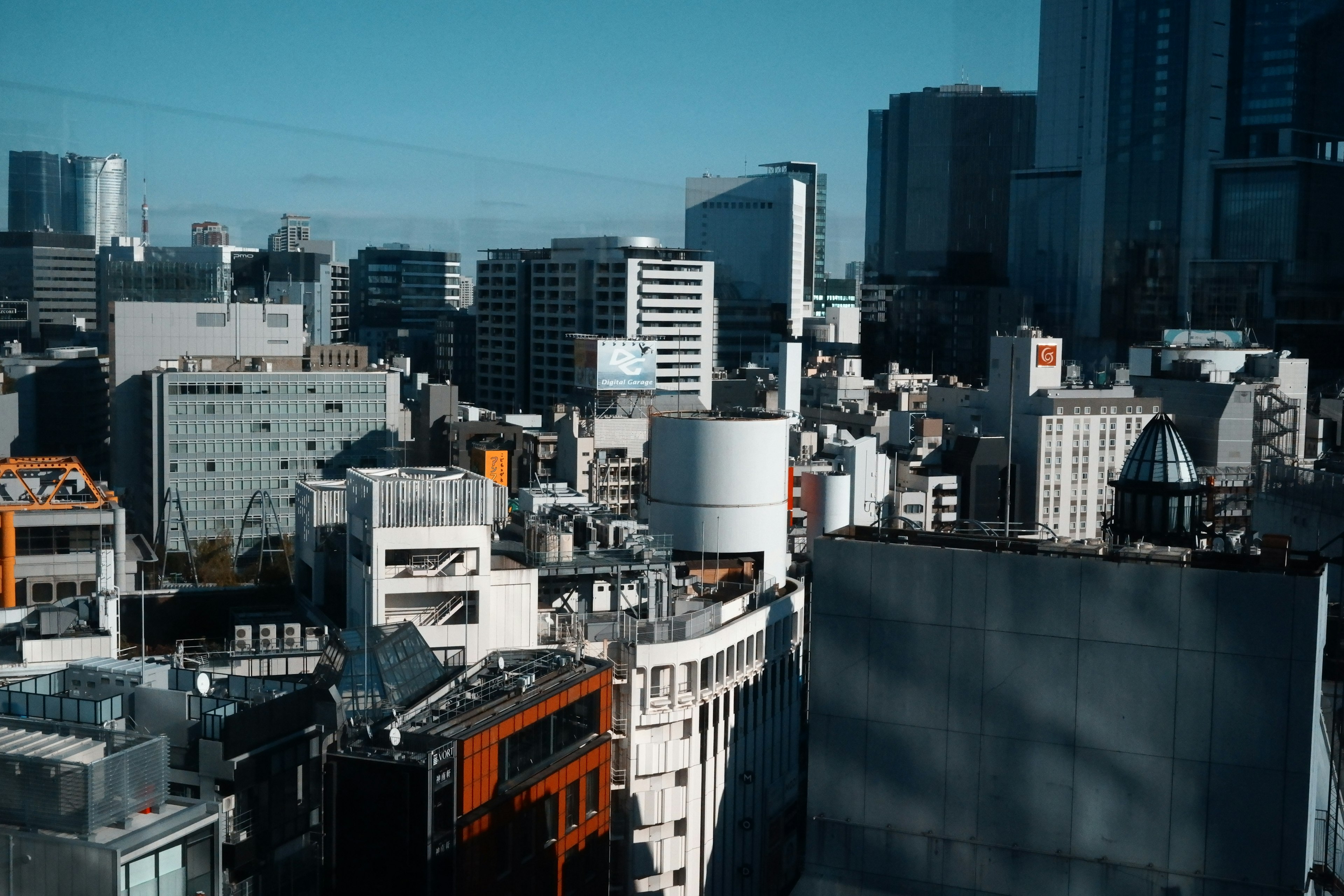 Paysage urbain sous un ciel bleu avec un mélange de bâtiments et de maisons