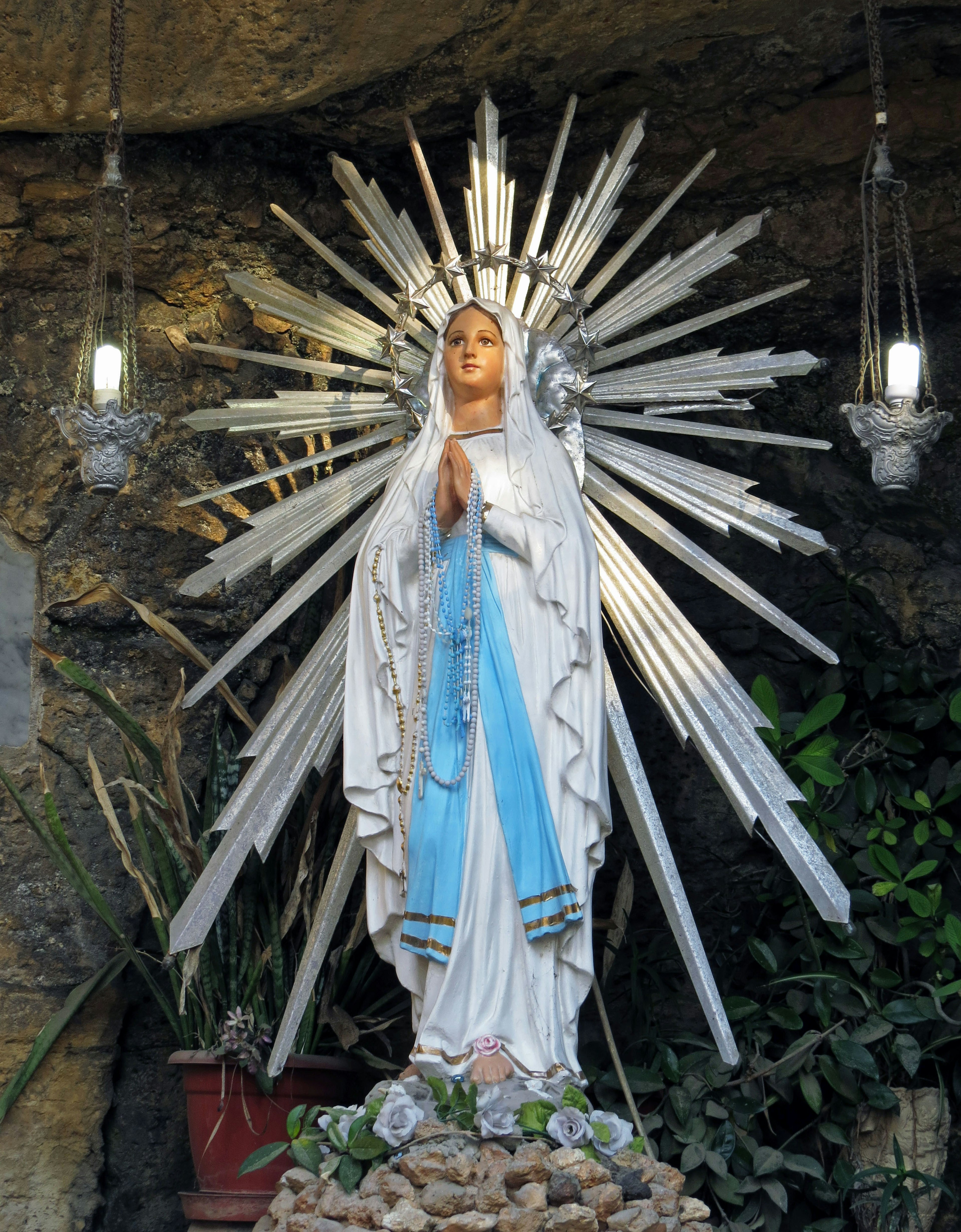 Estatua de la Virgen María con luz radiante detrás de ella