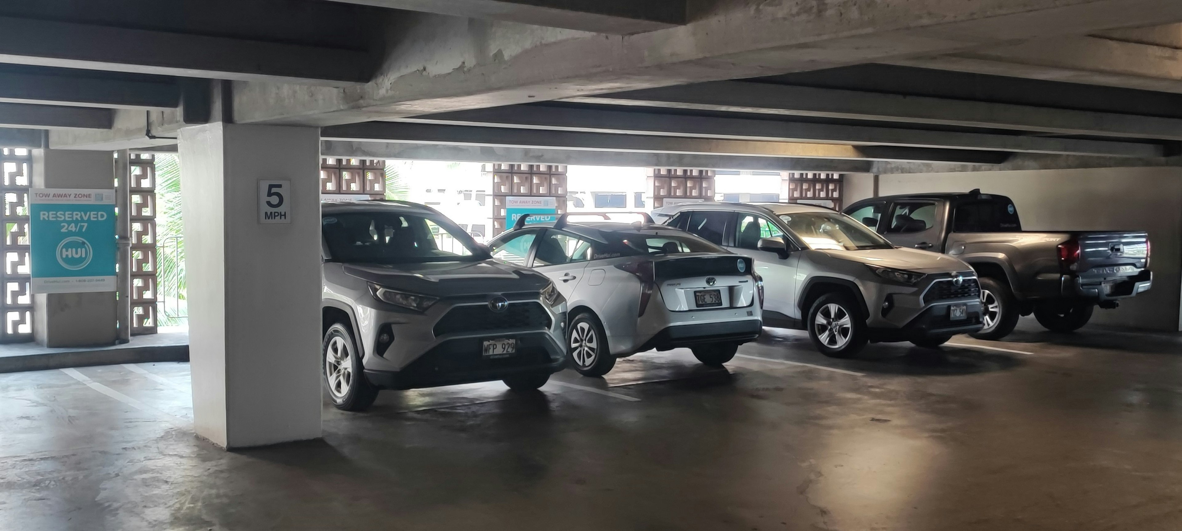 Plusieurs SUV garés dans un parking souterrain avec des murs en béton