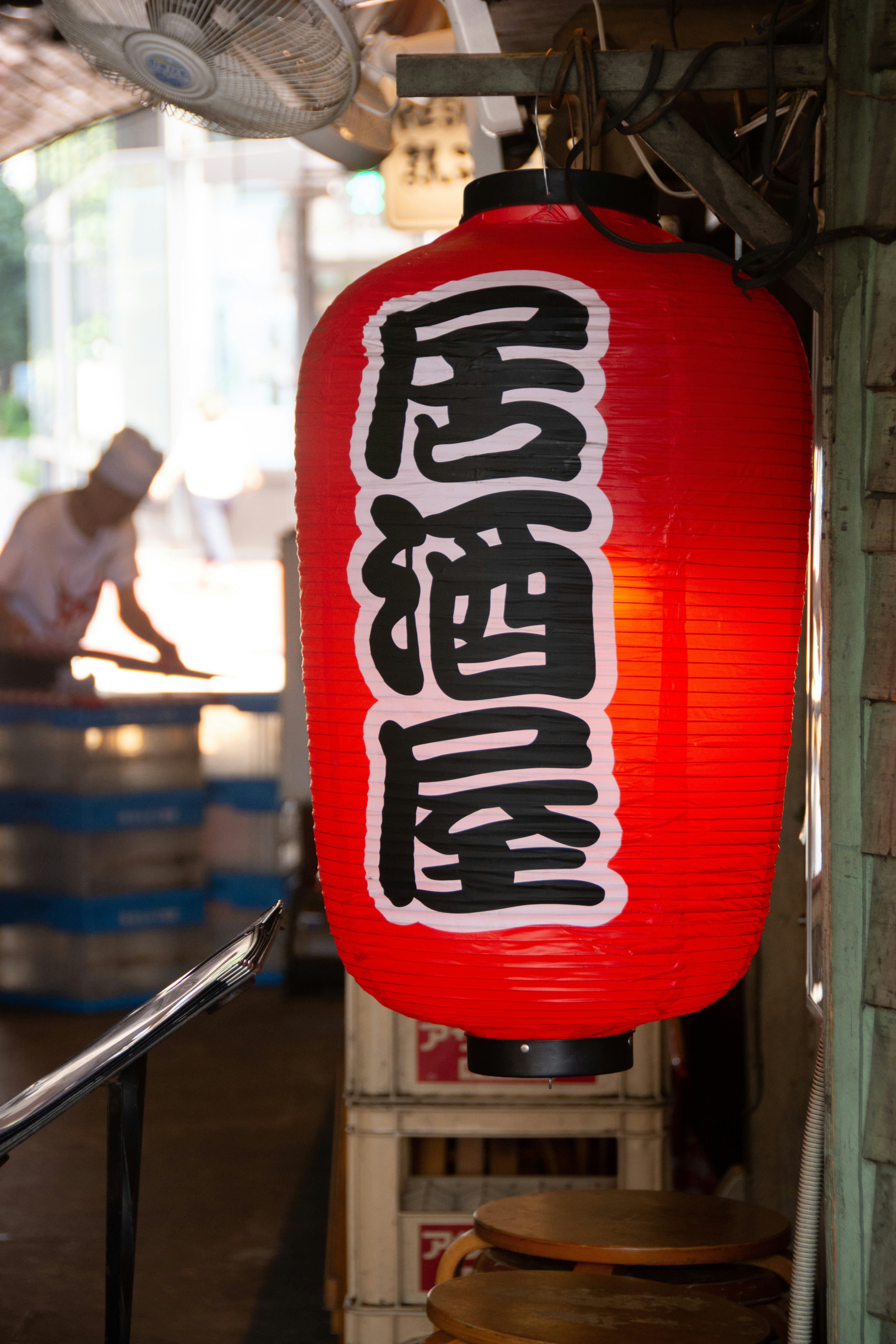 Red lantern hanging at the entrance of an izakaya