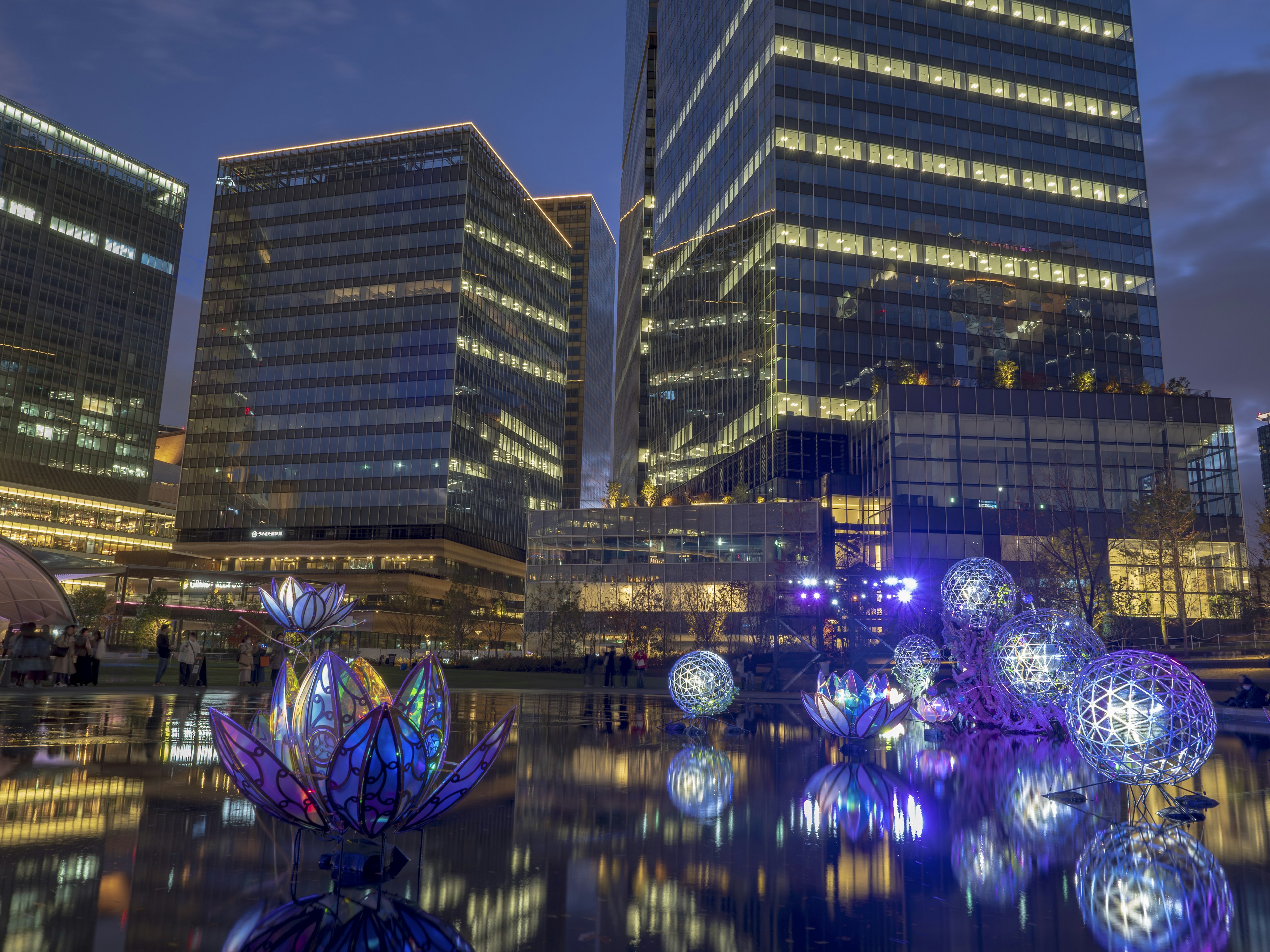 Stadtansicht bei Nacht mit beleuchteten Objekten auf dem Wasser