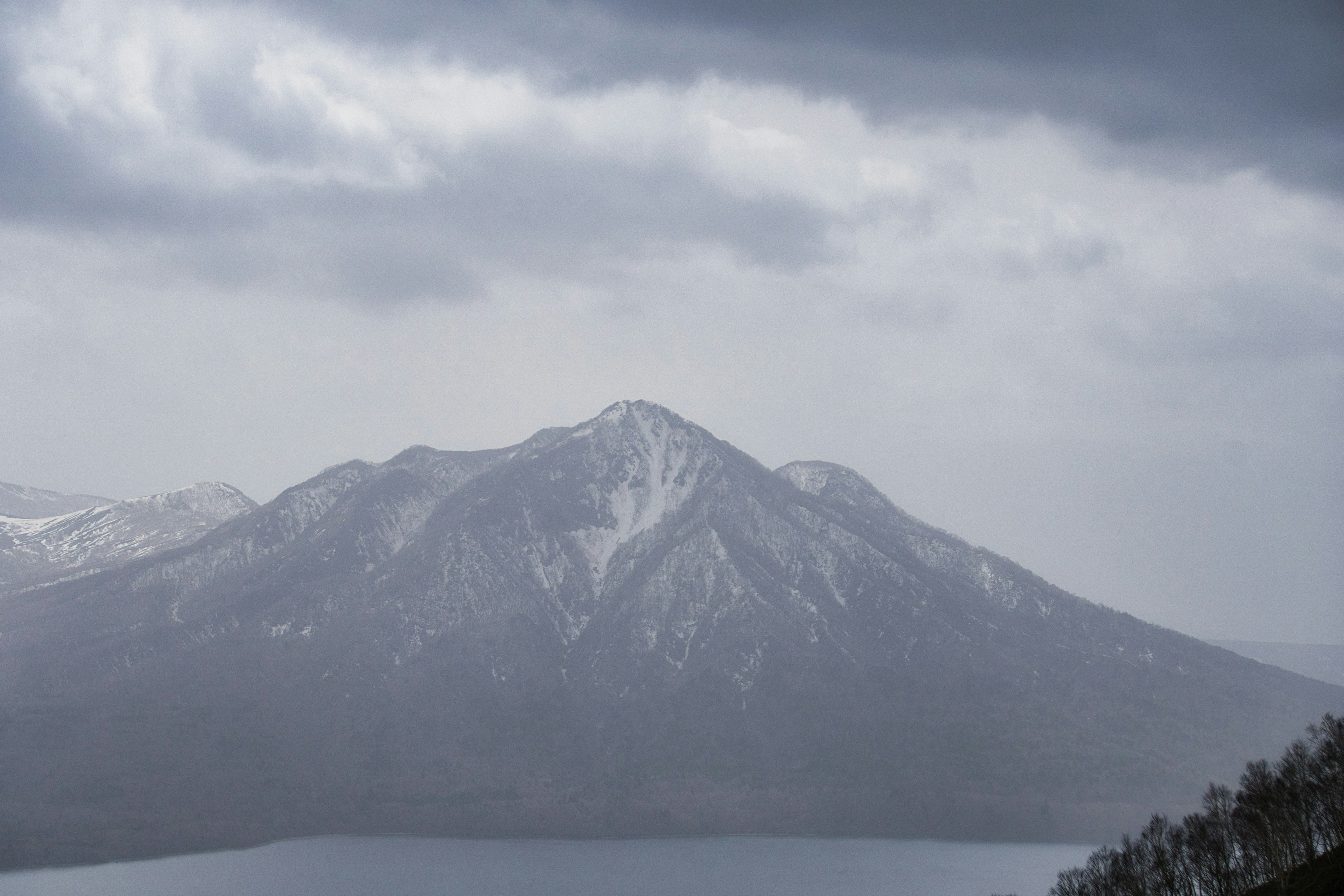 Snow-capped mountain under a cloudy sky