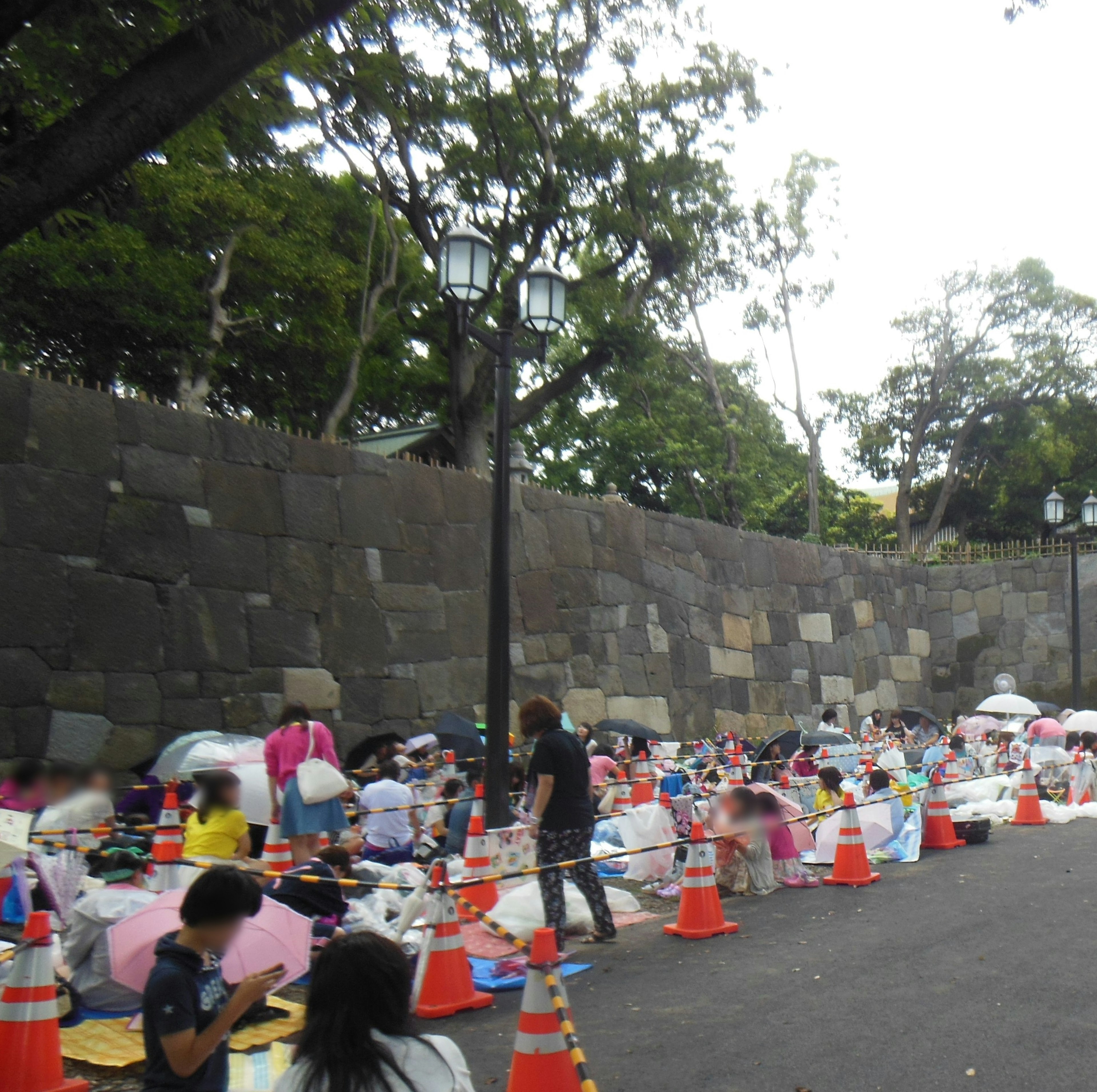 人々が色とりどりの傘の下で座っている公園の風景