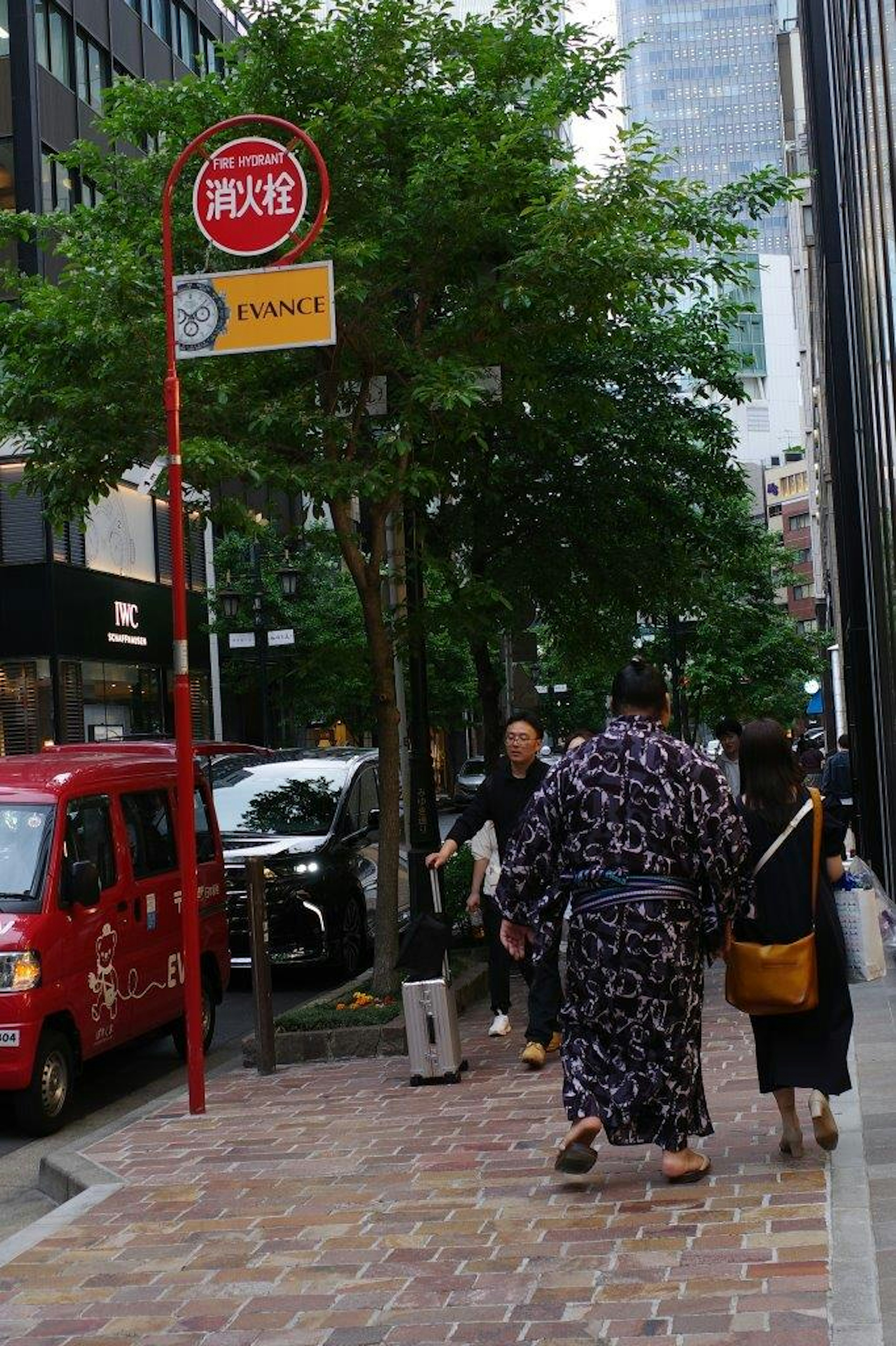 街を歩く人々とバス停がある都市の風景