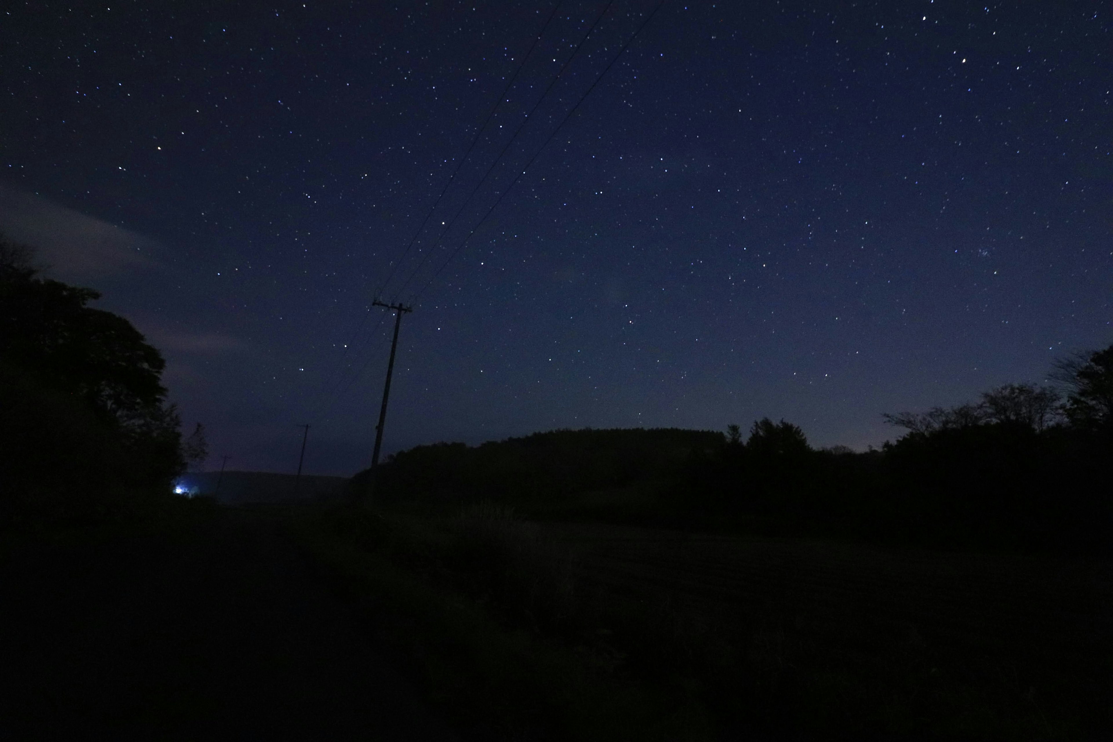 Paysage nocturne avec un ciel étoilé et silhouette de collines