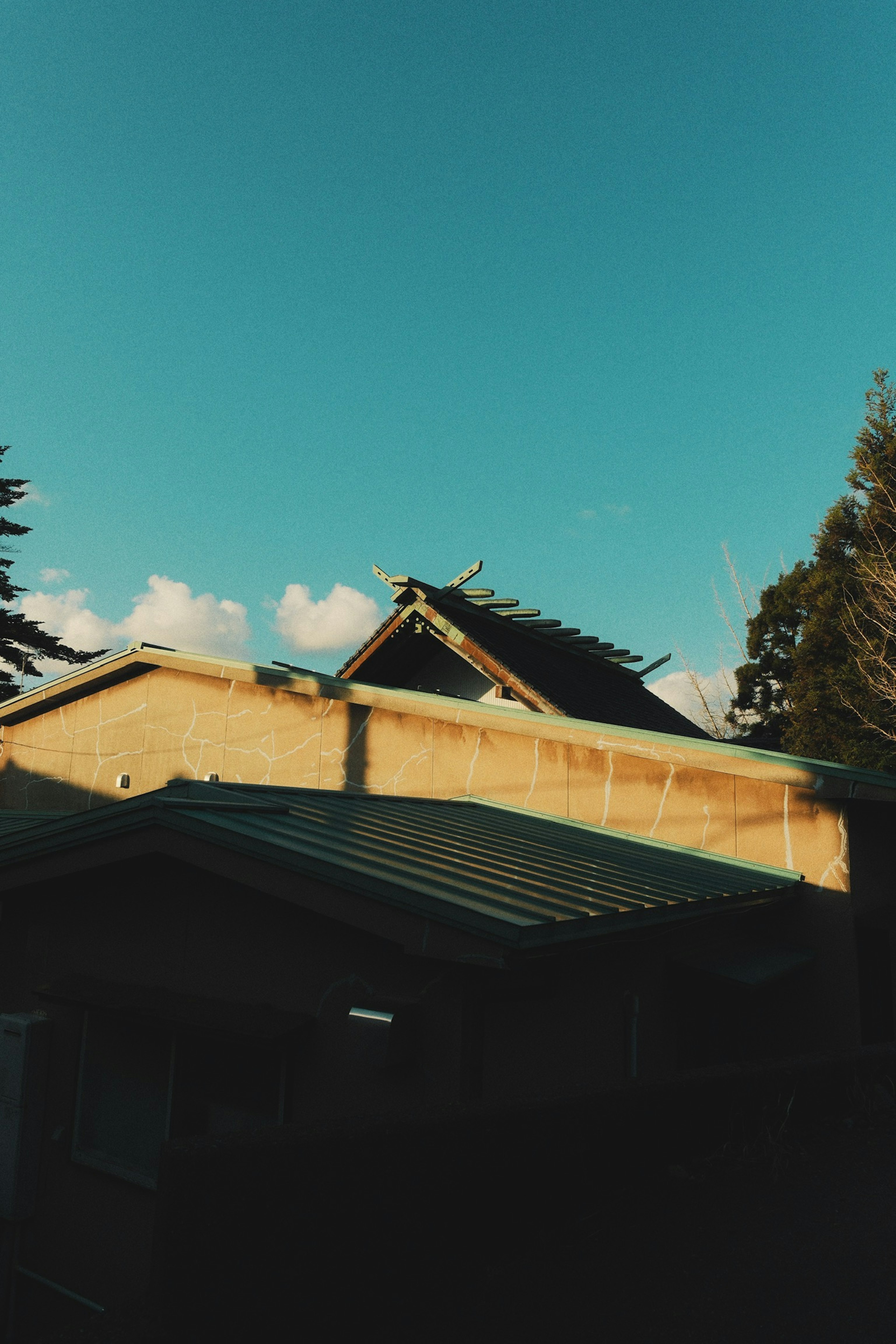 青空の下にある伝統的な日本の家屋の屋根