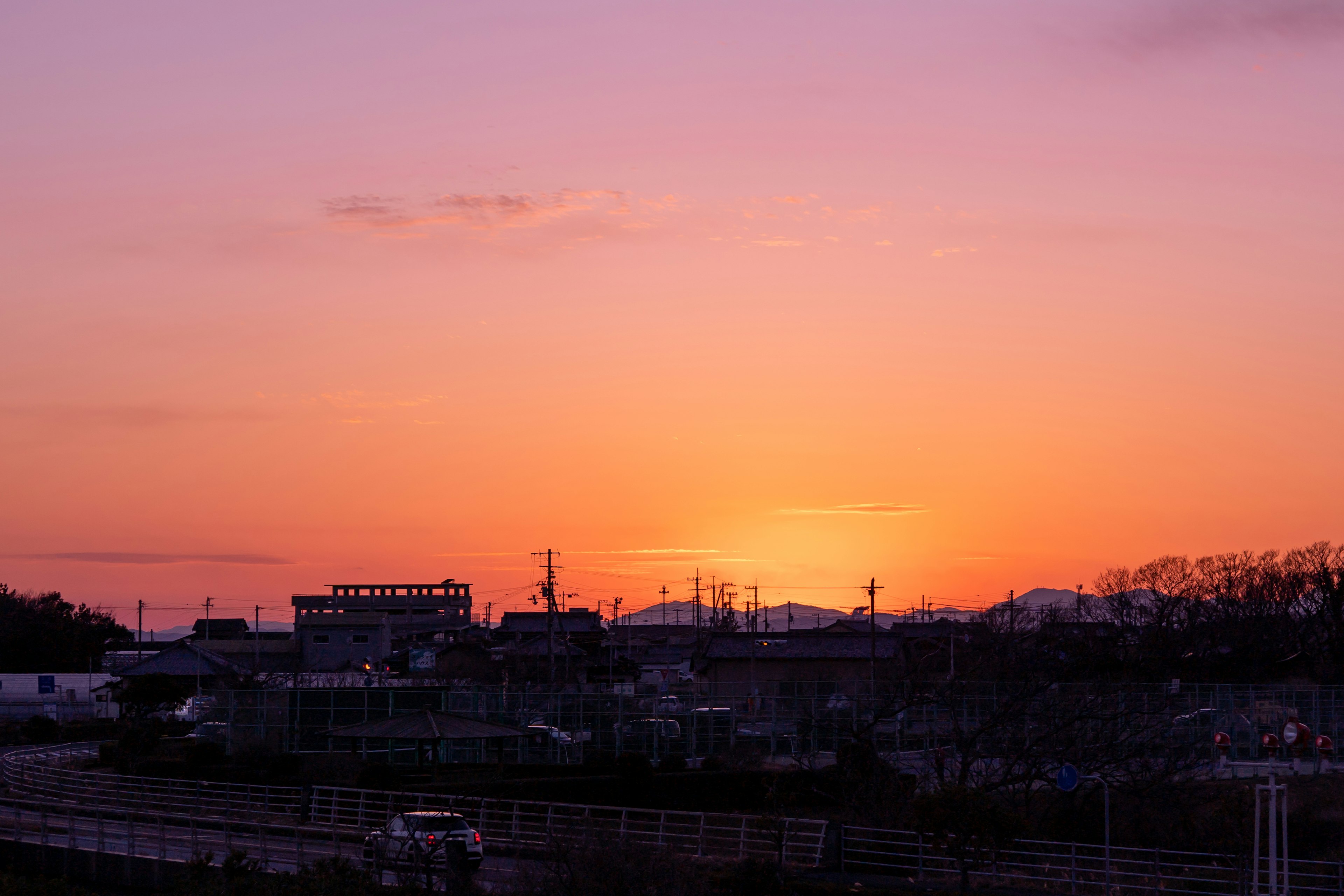 紫色の夕焼けとシルエットの建物が見える風景