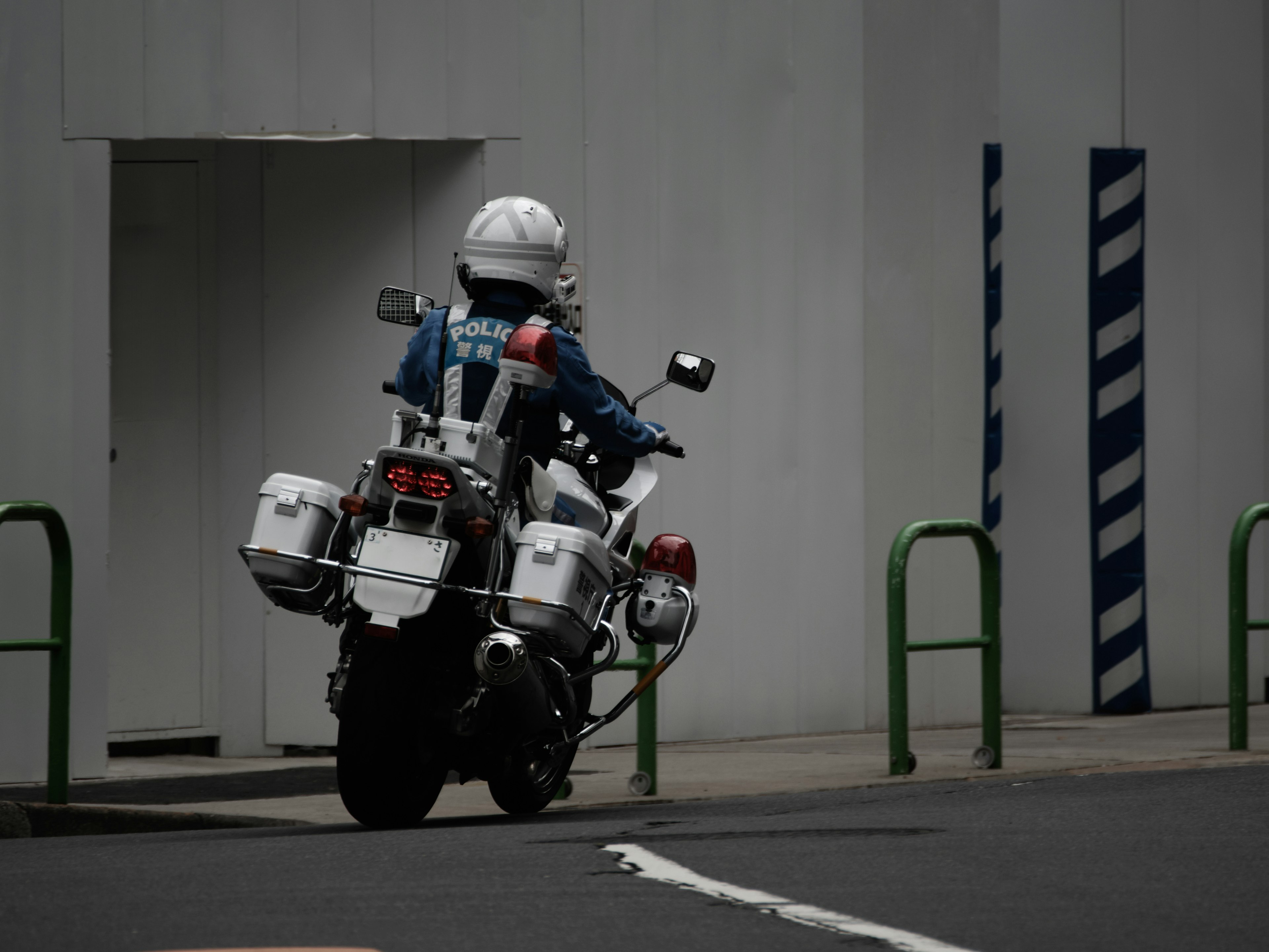 A police officer riding a white motorcycle leaving the scene