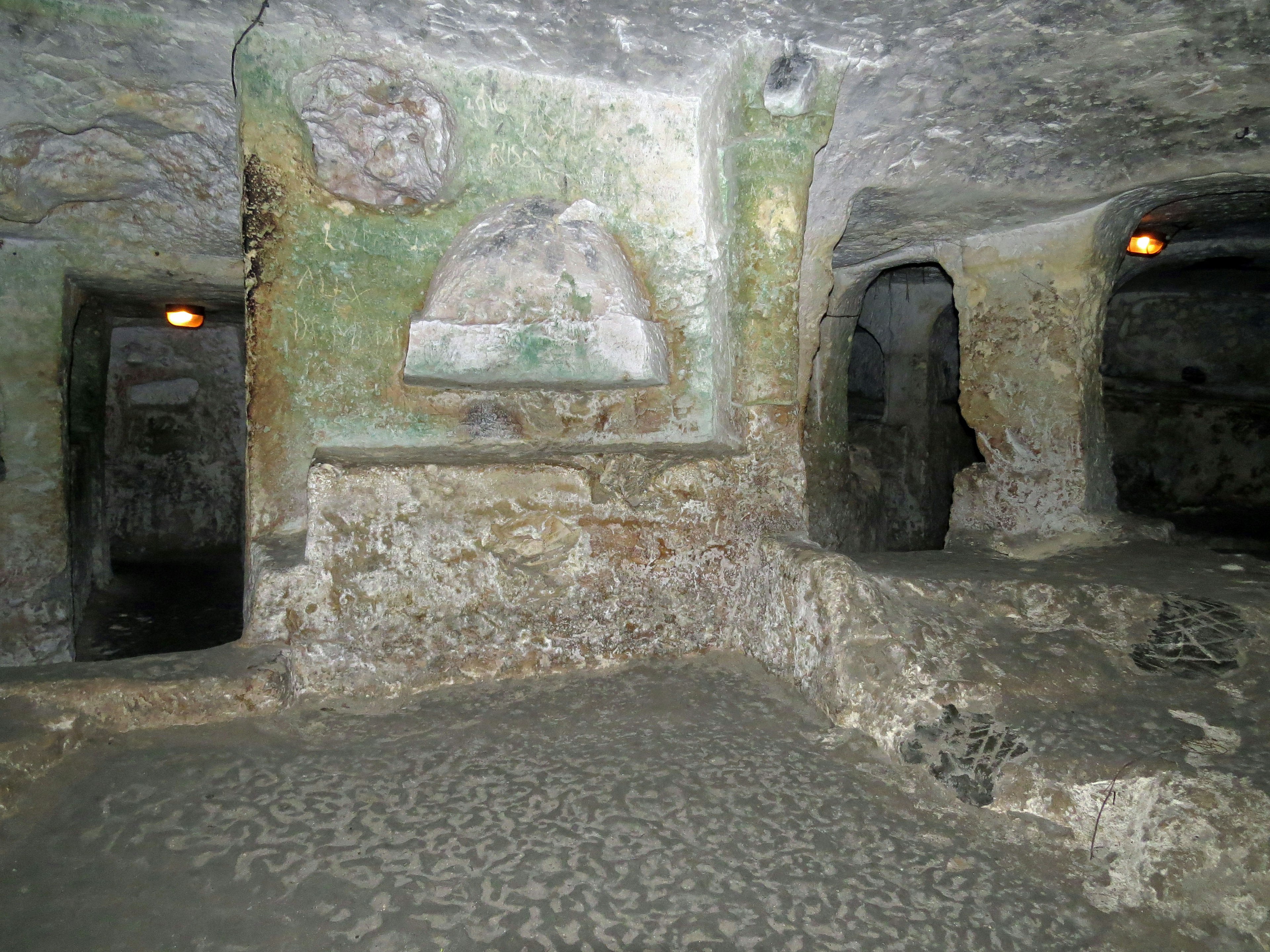 Espace souterrain avec des sculptures anciennes et des murs en pierre