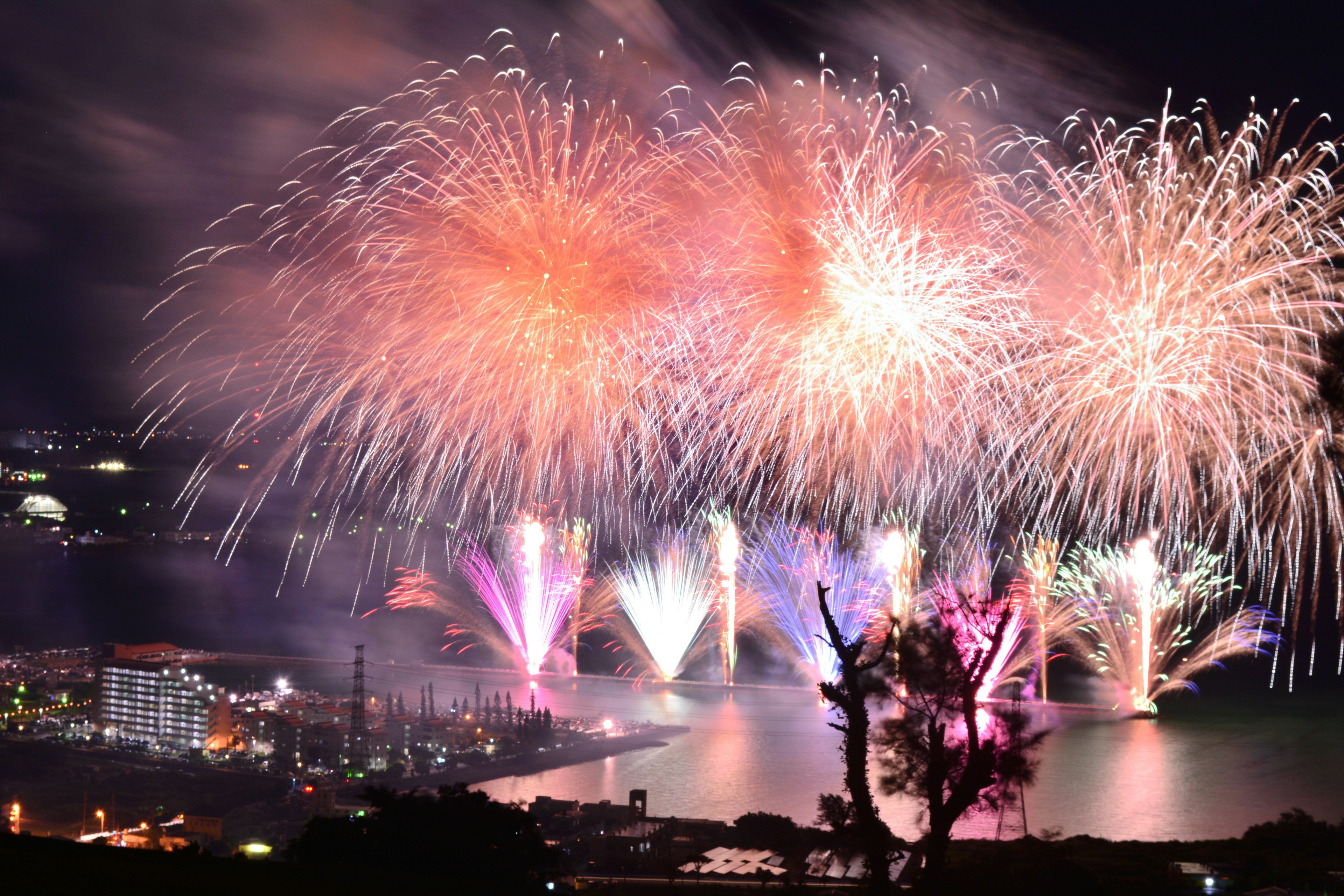 夜空に広がる色とりどりの花火が水面に映る美しい風景