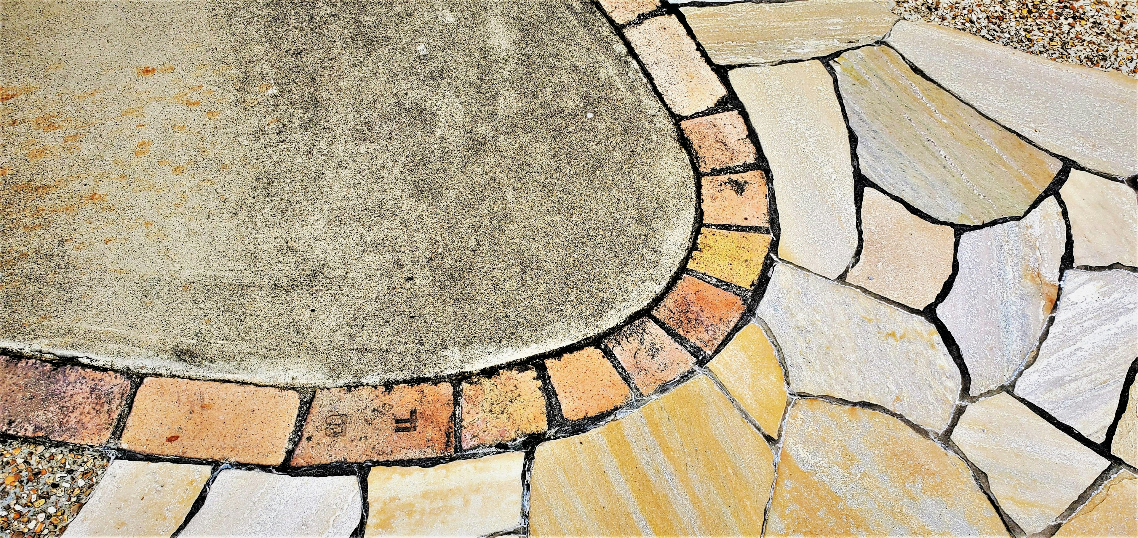 Smooth concrete and colorful stone tile border